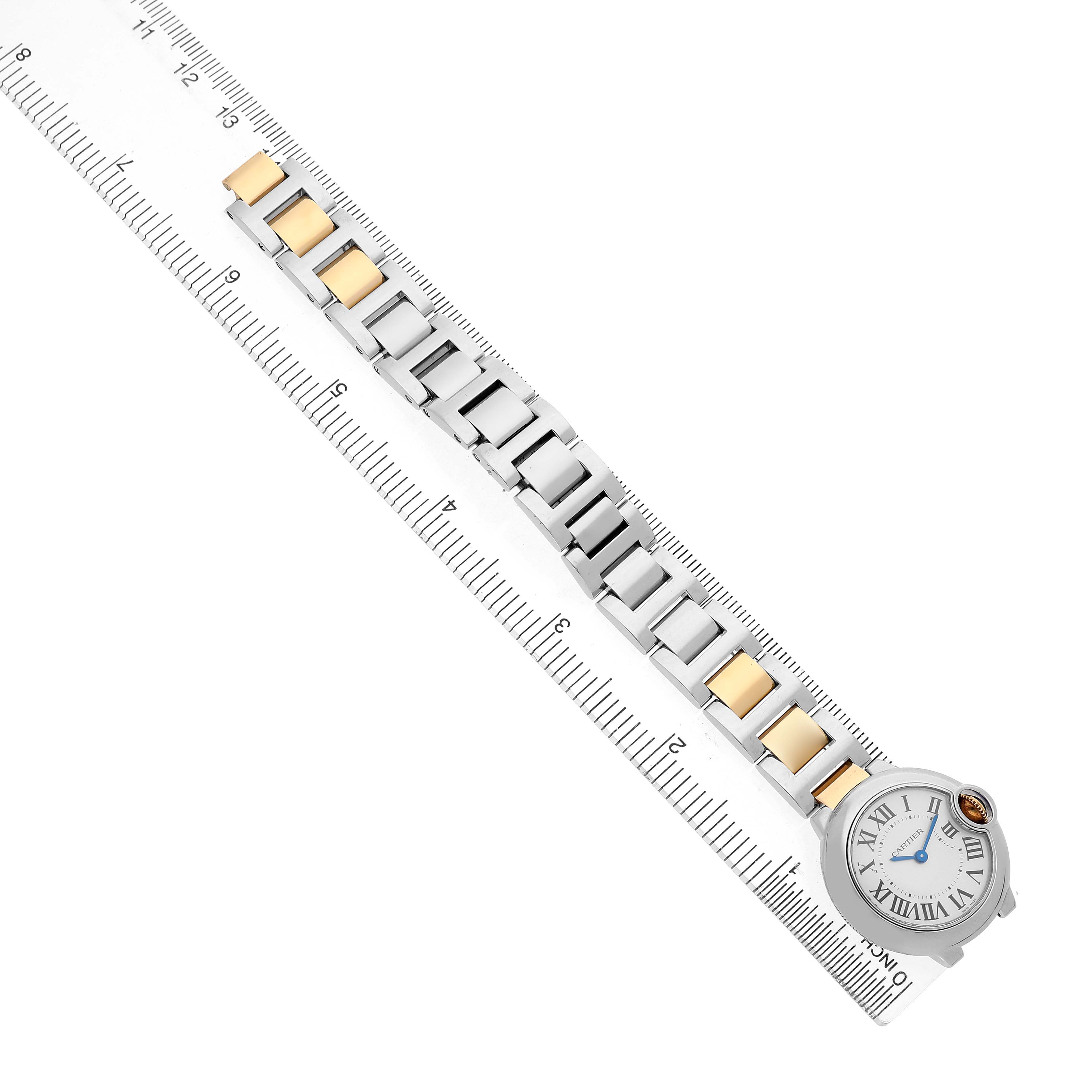 The Cartier Ballon Bleu W69007Z3 Women's Steel and Gold (two tone) Silver Dial watch is shown from a top-down angle, highlighting the full bracelet and face beside a ruler.