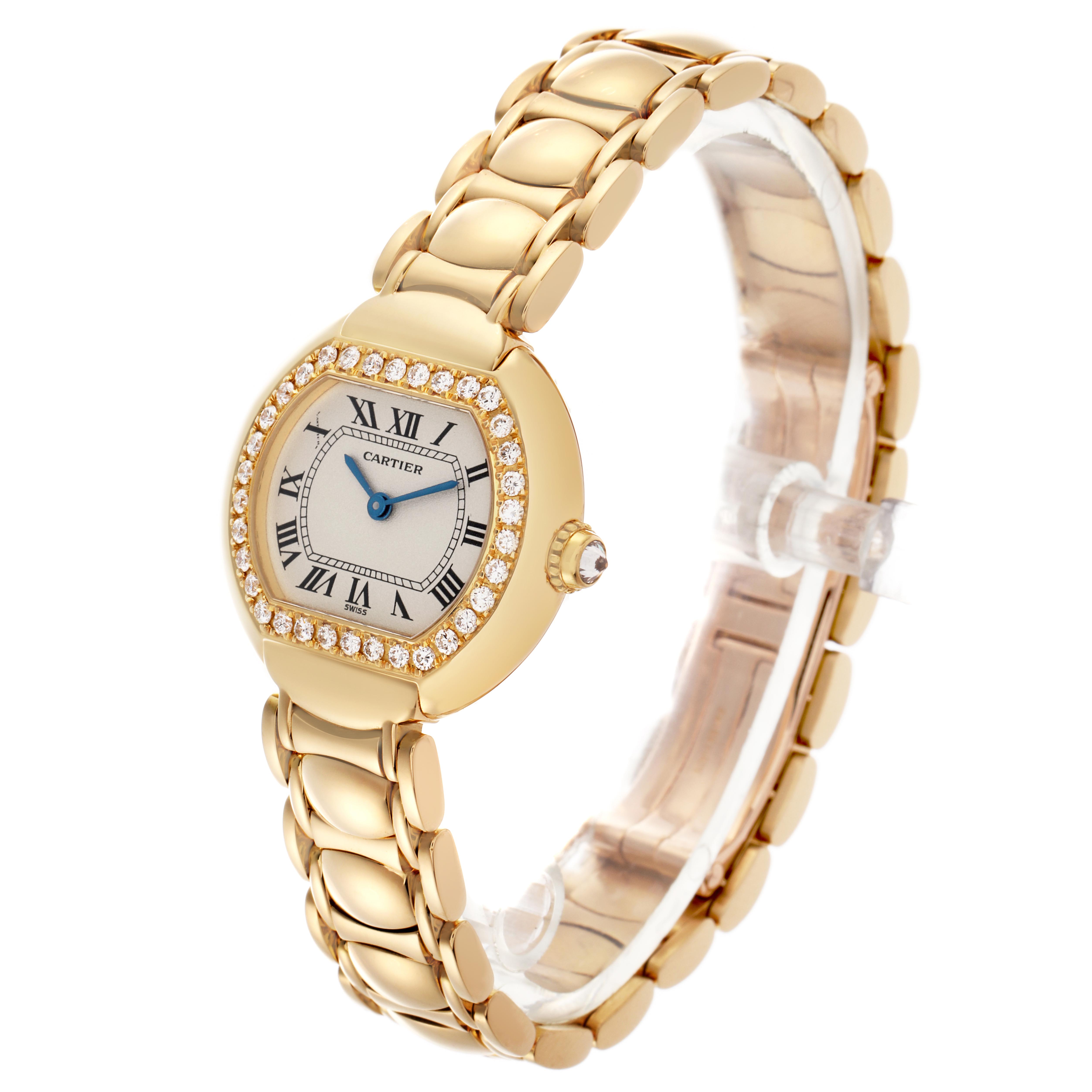 The Cartier Tortue WB6009L8 Women
s Yellow Gold Silver Dial WB6009L8 Women
s Yellow Gold Silver Dial watch is shown at an angle highlighting its diamond bezel, Roman numeral face, and gold bracelet.