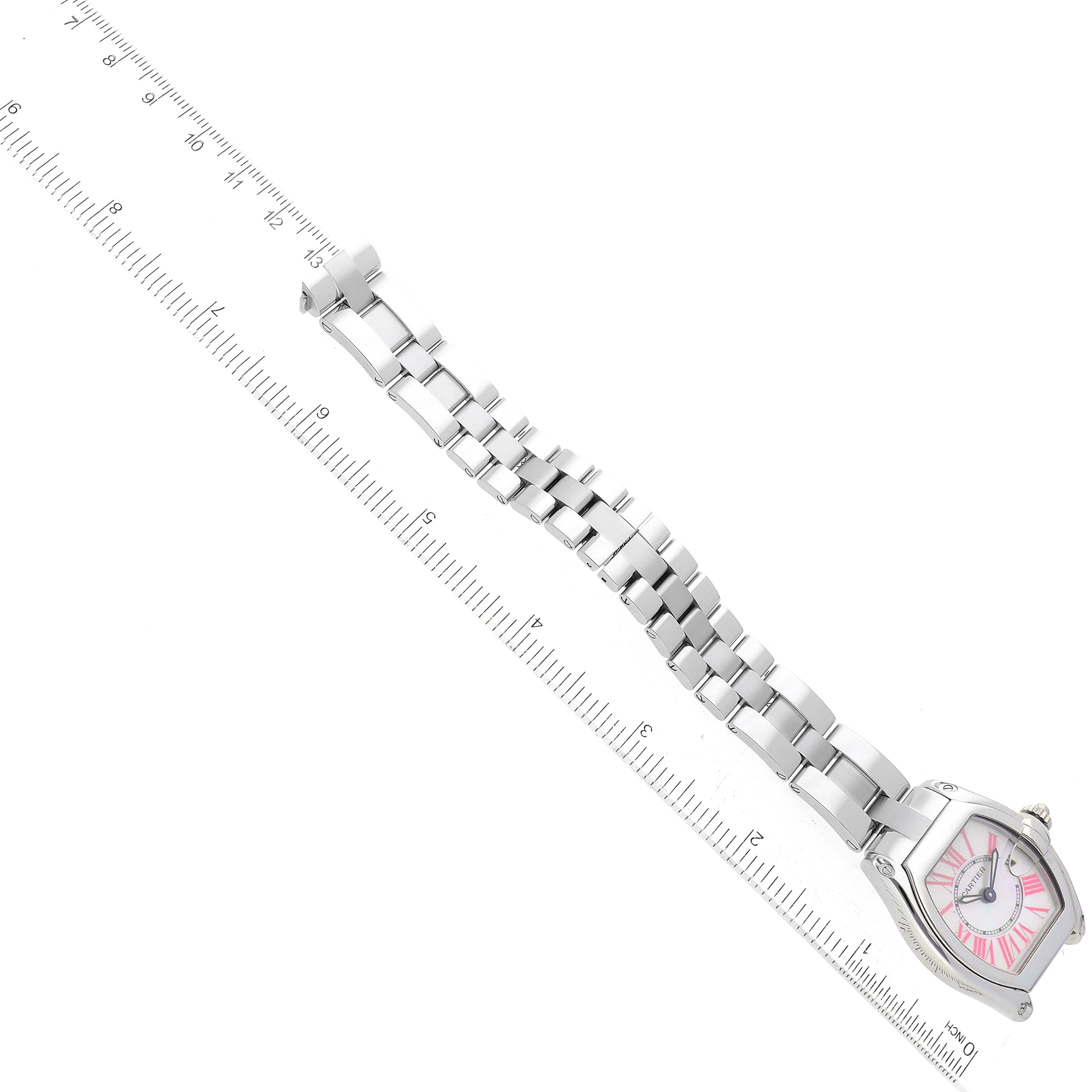 The Cartier Roadster W6206006 Women's Stainless Steel Mother of Pearl Dial W6206006 Women's Stainless Steel Mother of Pearl Dial watch is shown laid flat, displaying the face, case, and metal bracelet next to a ruler.