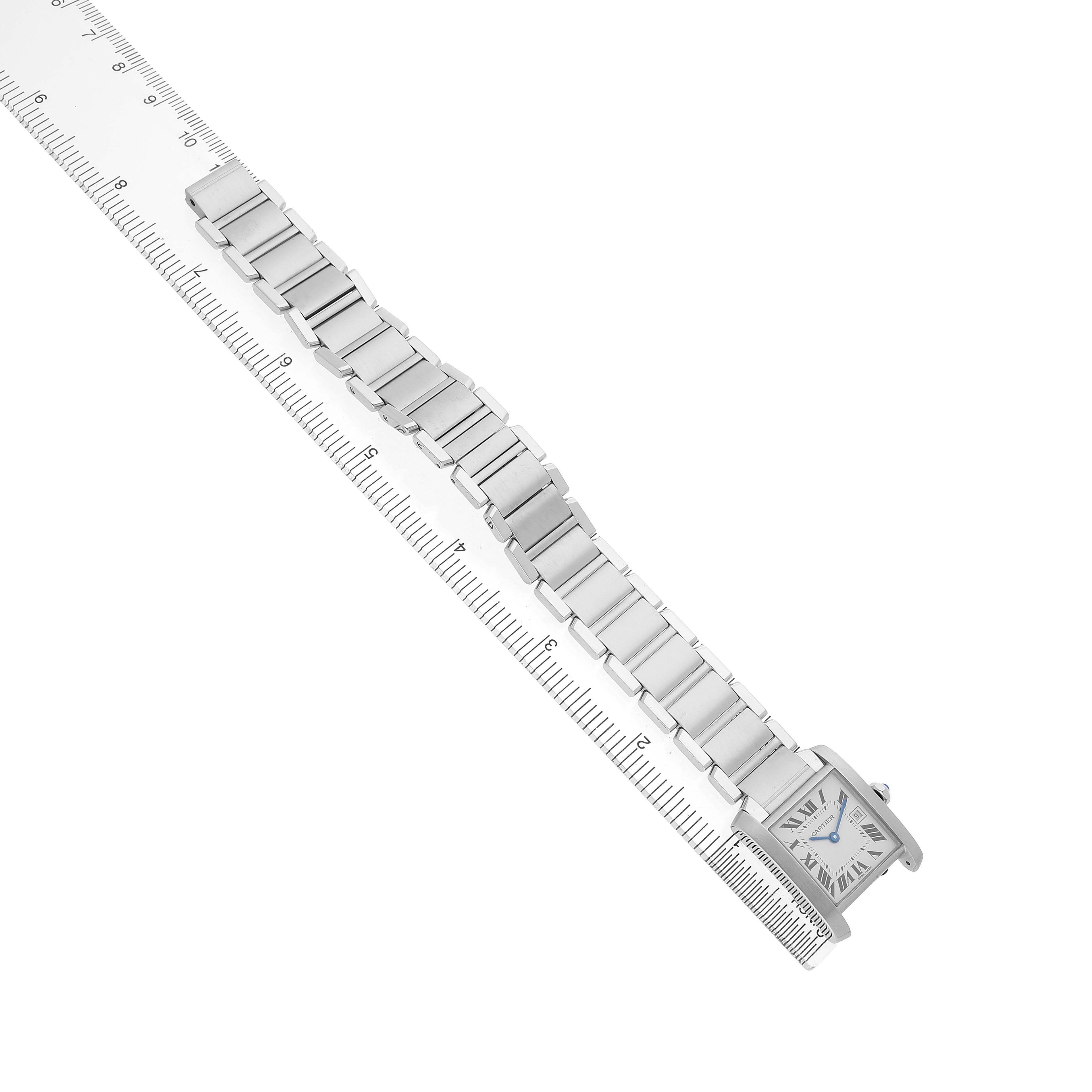 The Cartier Tank Francaise W51011Q3 Women's Stainless Steel Silver Dial watch is shown from an overhead angle, revealing the face and full bracelet alongside a ruler for scale.