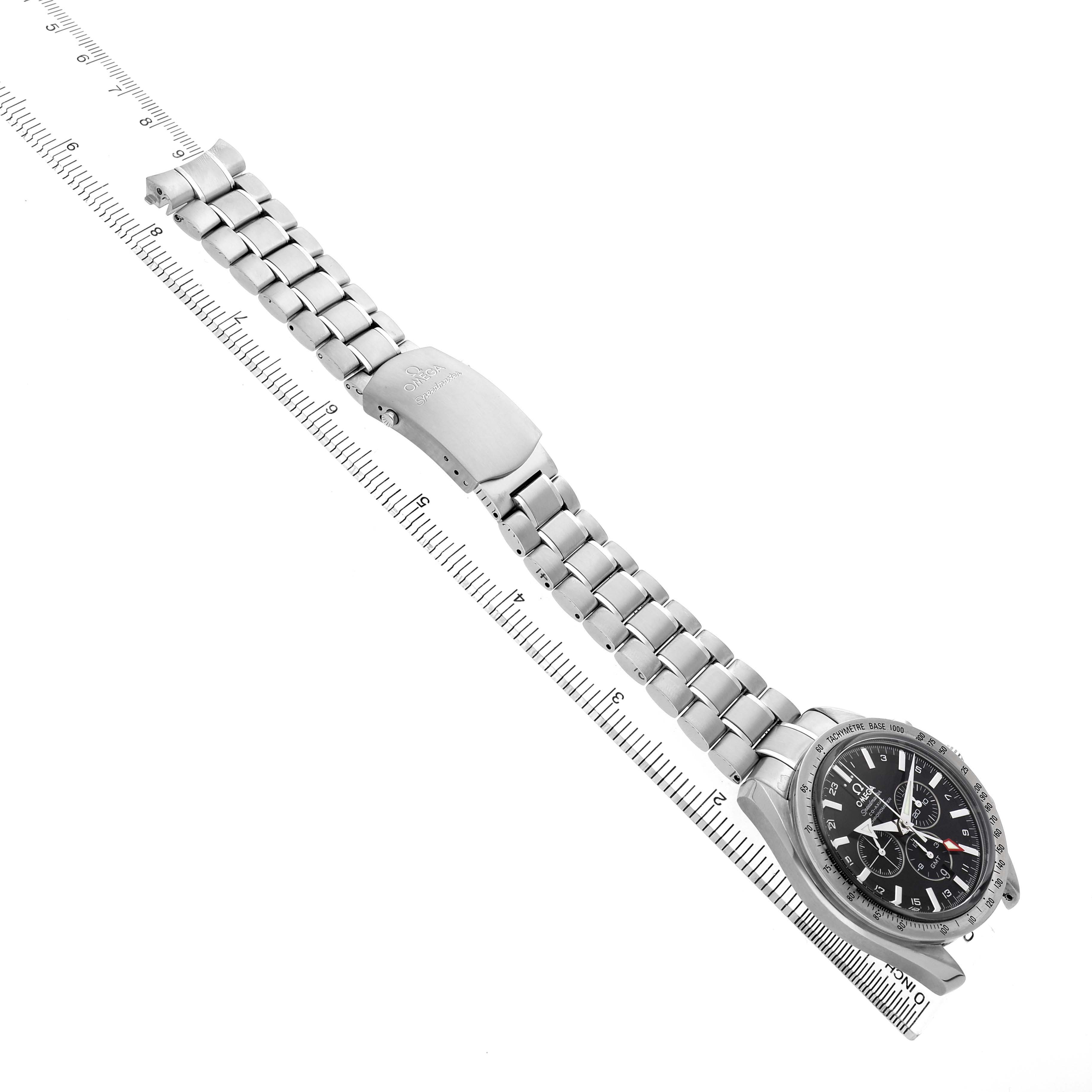 The Omega Speedmaster 3581.50.00 Men's Stainless Steel Black Dial watch is shown at an oblique angle with a silver bracelet and clasp visible alongside a ruler for scale.