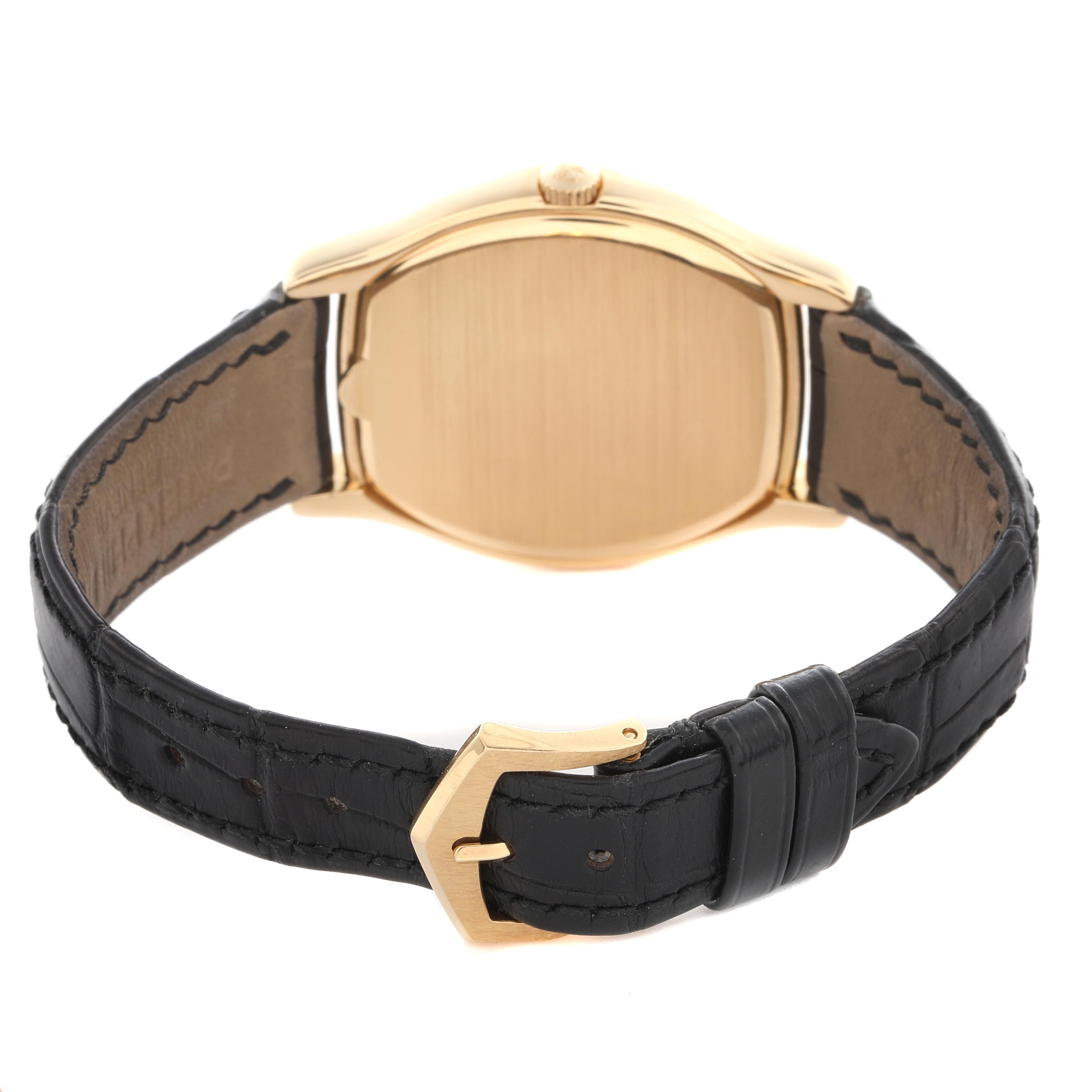 The Patek Philippe Complications 5040J Men
s Yellow Gold Silver Dial 5040J Men
s Yellow Gold Silver Dial watch is shown from the back, highlighting the case, crown, and black leather strap with a gold buckle.