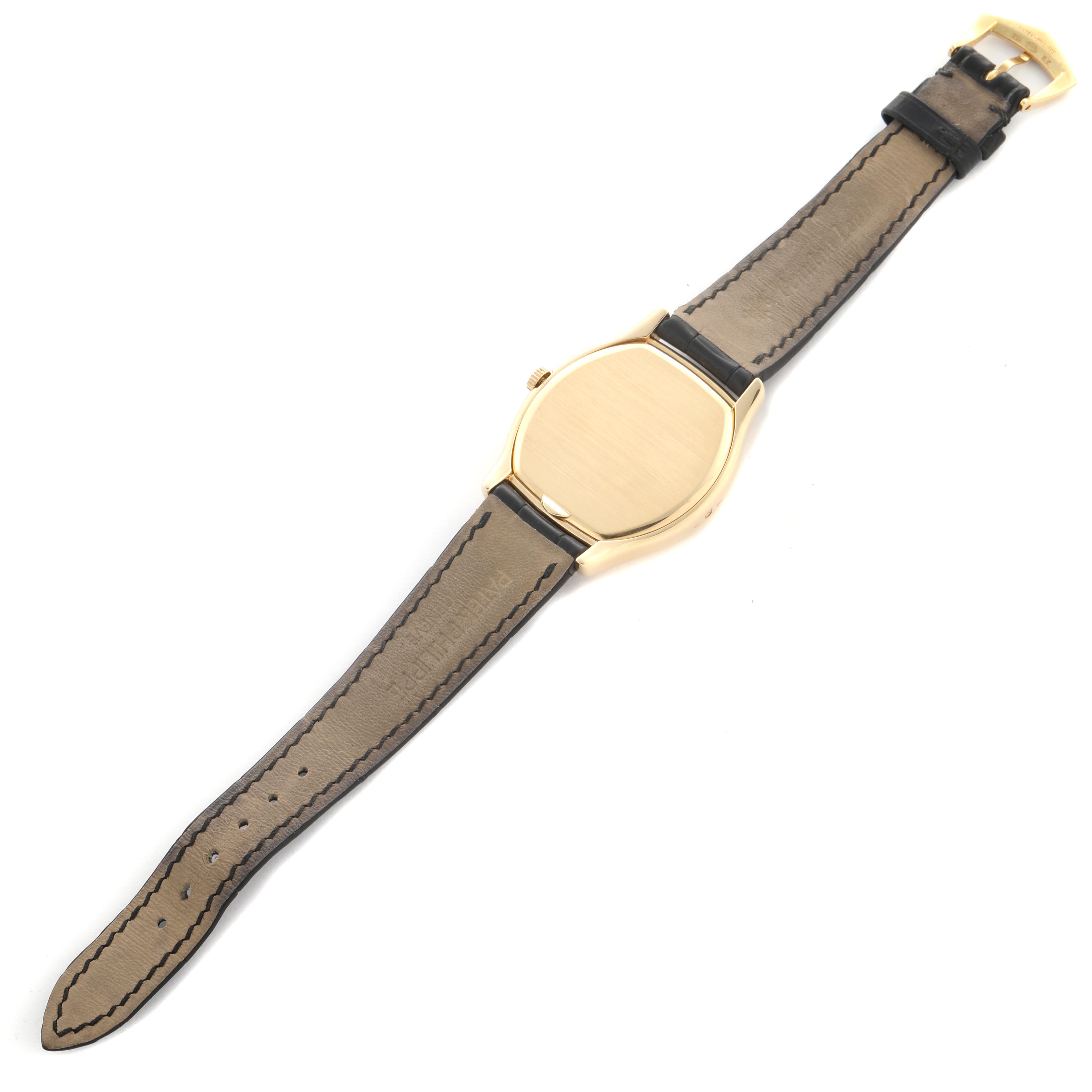 The image shows the back view of a Patek Philippe Complications 5040J Men
s Yellow Gold Silver Dial 5040J Men
s Yellow Gold Silver Dial watch, displaying its leather strap and gold case.