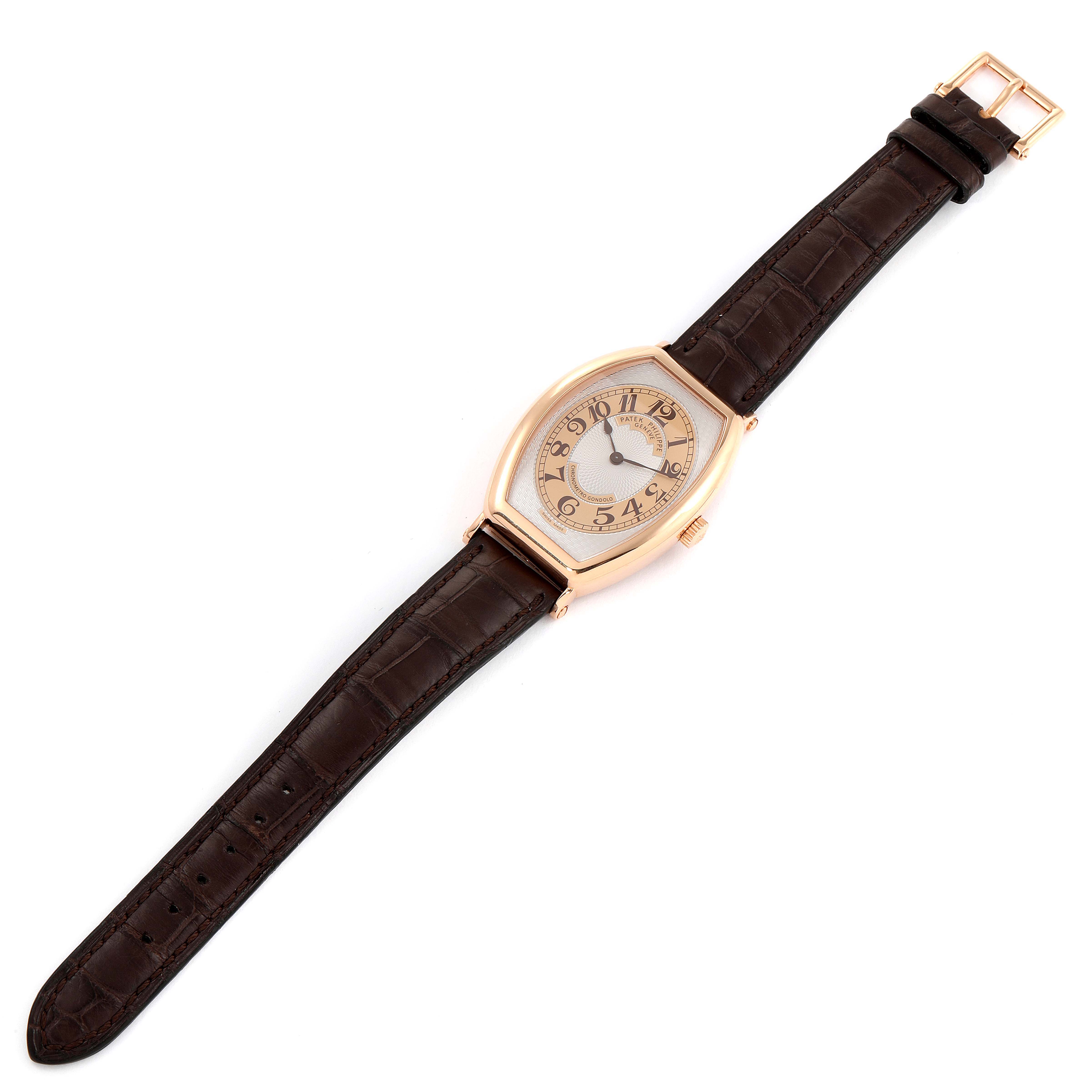 This image shows a top-down view of a Patek Philippe Gondolo 5098R Men's Rose Gold Silver Dial 5098R Men's Rose Gold Silver Dial watch with a brown leather strap and a gold-tone case.