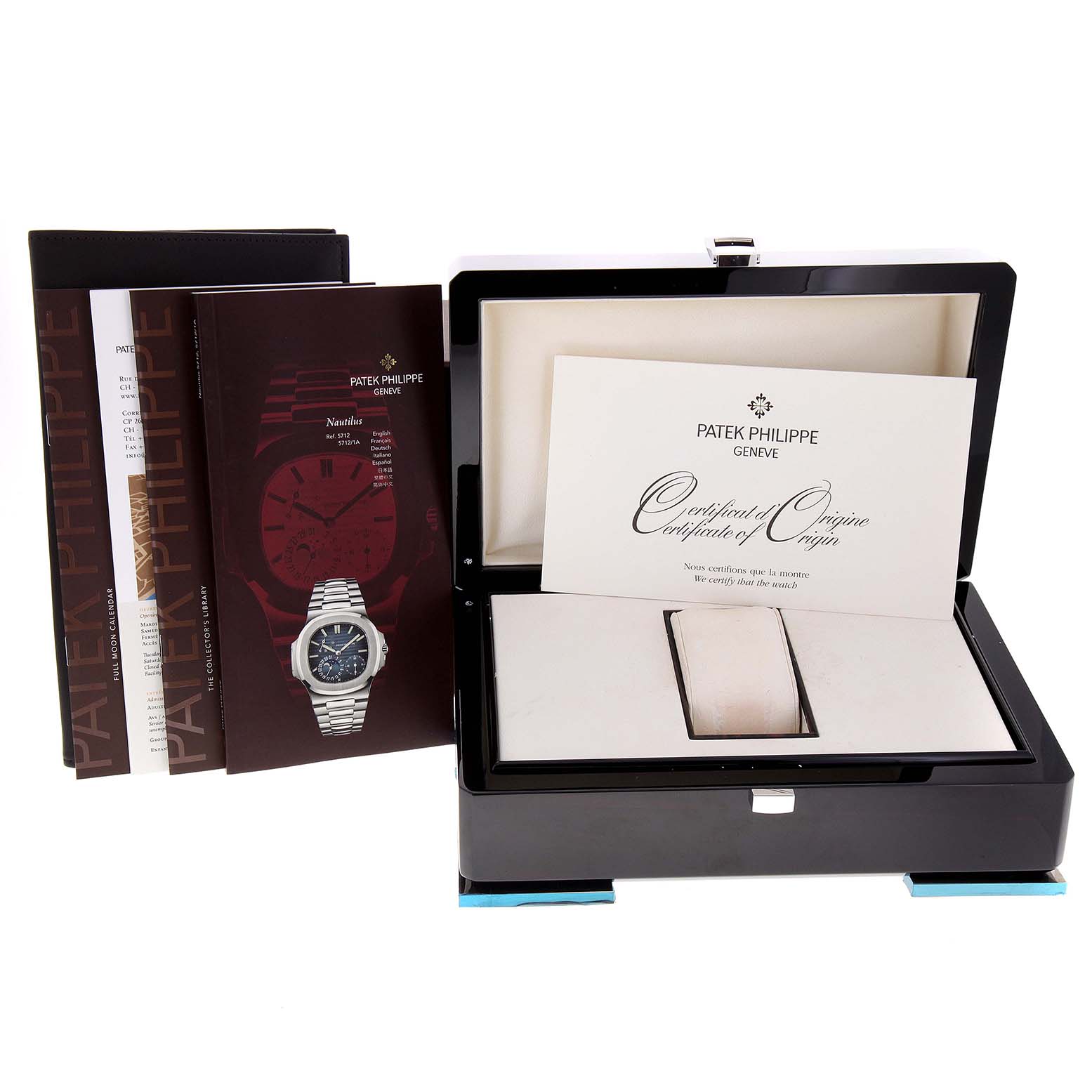 The image shows a Patek Philippe Nautilus 5712G/001 Men
s White Gold Grey Dial 5712G/001 Men
s White Gold Grey Dial watch box, certificate of origin, and instruction manuals from a front angle.