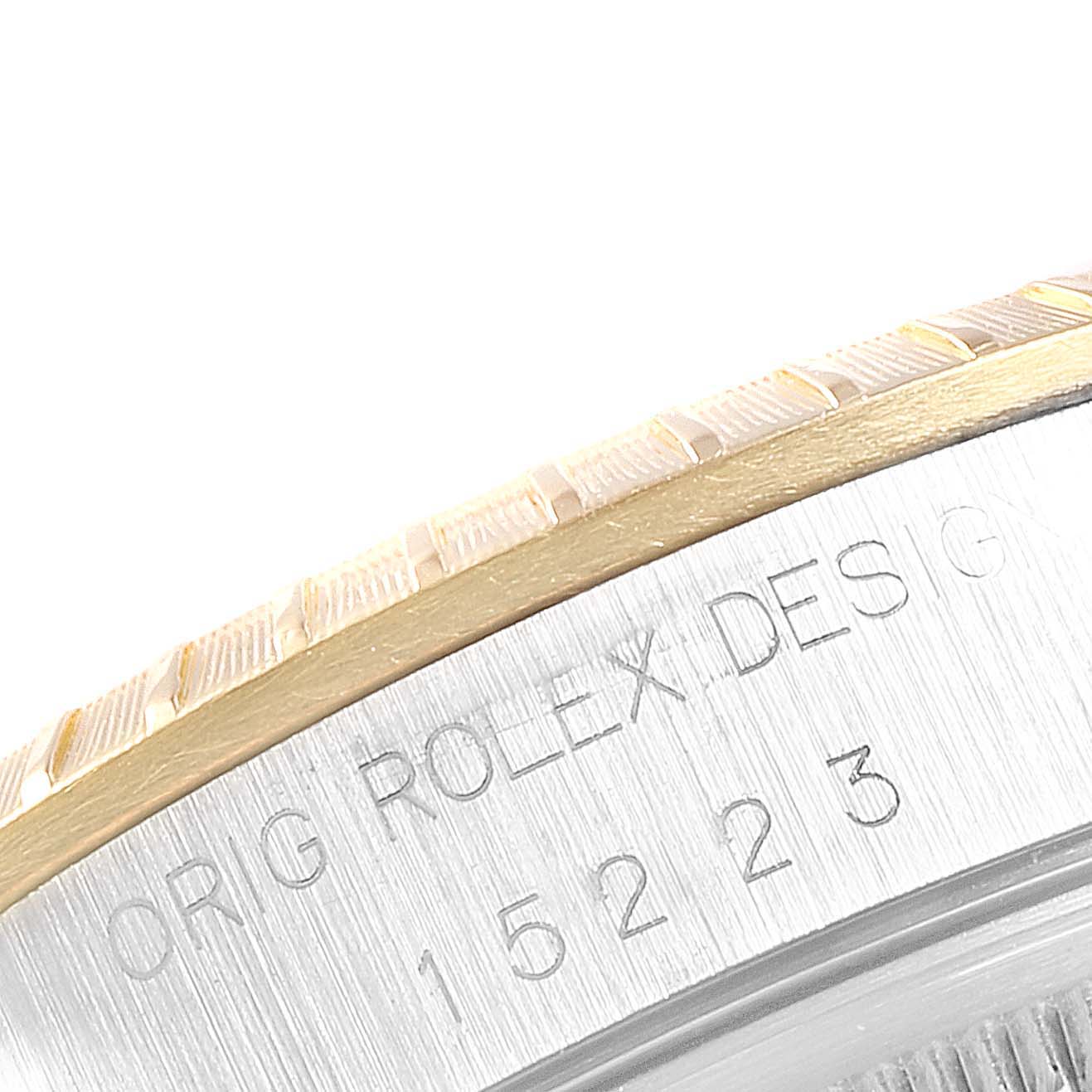 This close-up image shows part of the bezel and engraved casing of a Rolex Date 15223 Men's Steel and Gold (two tone) White Dial 15223 Men's Steel and Gold (two tone) White Dial model watch.