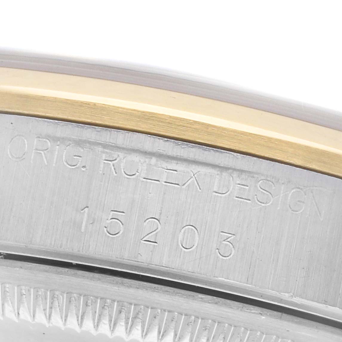 The image shows a close-up of the side edge of a Rolex Date 15203 Men
s Steel and Gold (two tone) Champagne Dial 15203 Men
s Steel and Gold (two tone) Champagne Dial model, highlighting the serial number and "Orig. Rolex Design" engraving.