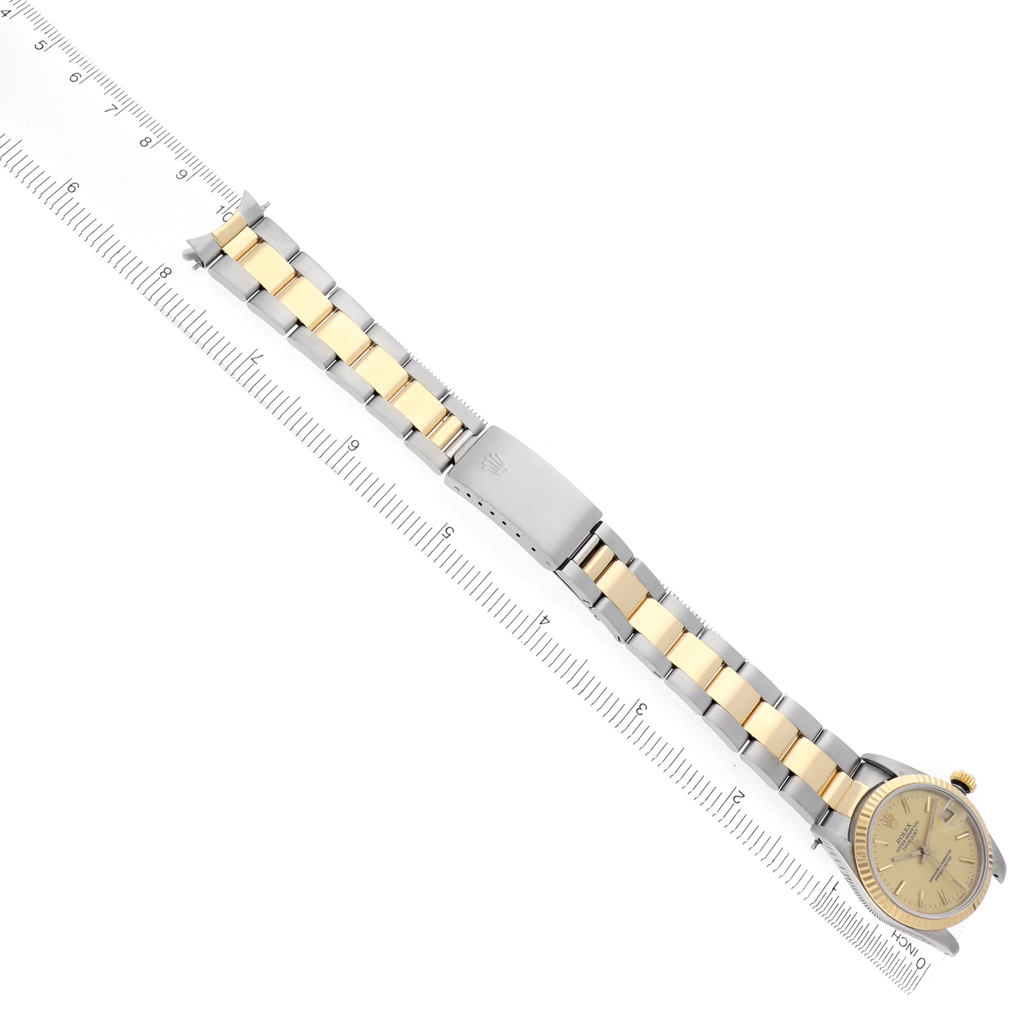 The image shows a Rolex Mid-Size 68273 Women
s Steel and Gold (two tone) Champagne Dial 68273 Women
s Steel and Gold (two tone) Champagne Dial watch in a top-down angle, displaying the dial, bracelet, and clasp against a ruler for scale.