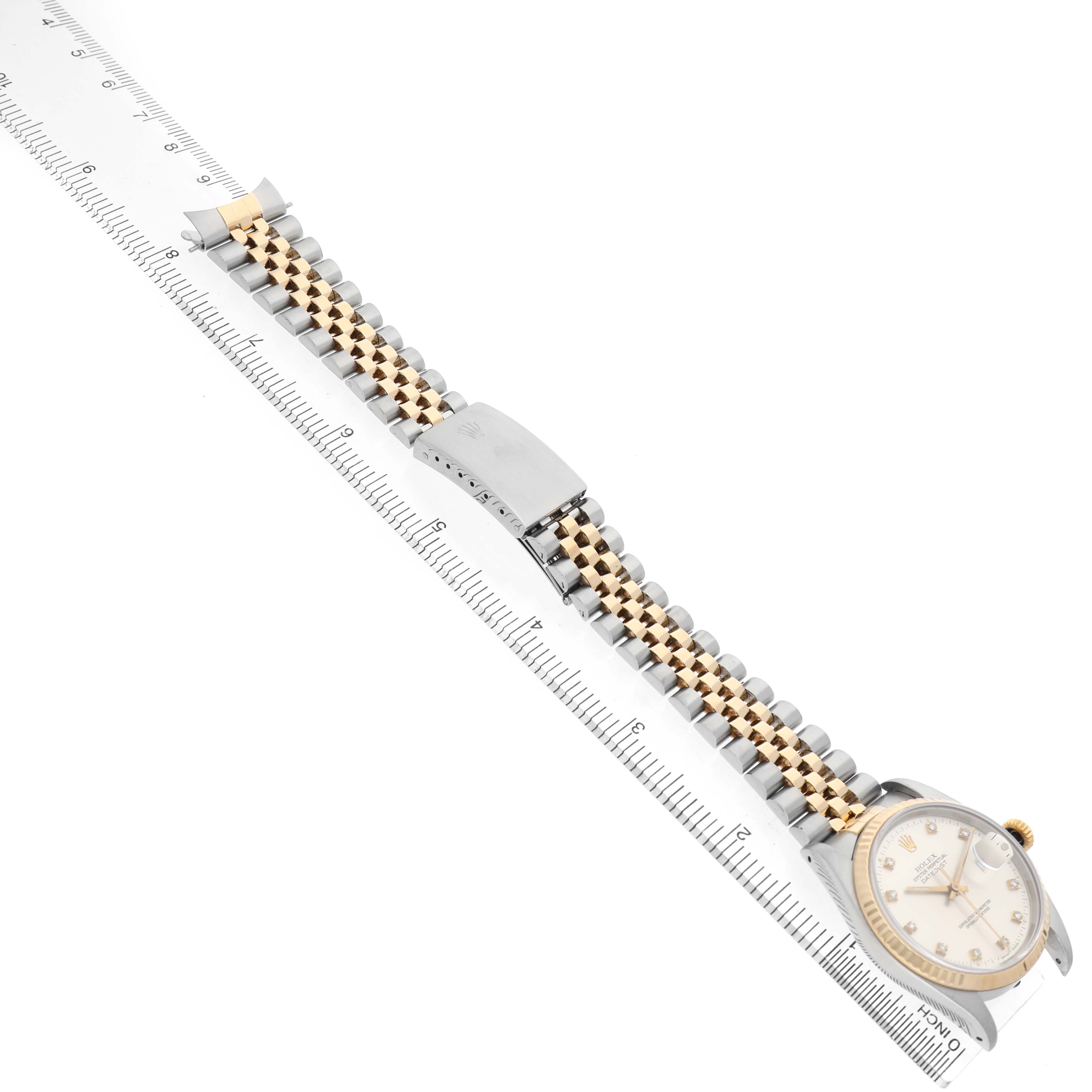 The Rolex Datejust 16233 Men's Stainless Steel Silver Dial watch is shown horizontally with a two-tone bracelet and the face visible, next to a ruler for scale.