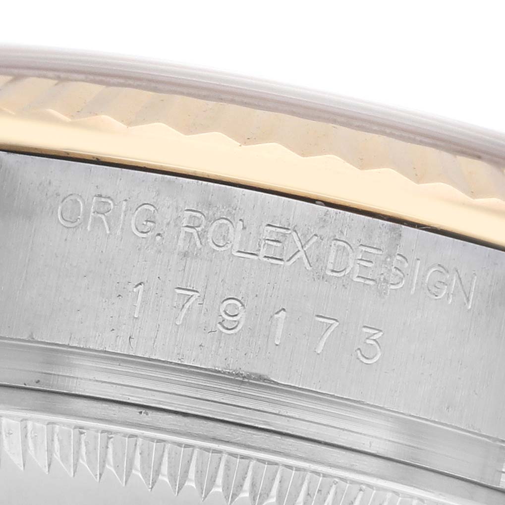 The image shows a close-up of the side of a Rolex Datejust 179173 Women's Steel and Gold (two tone) Champagne Dial 179173 Women's Steel and Gold (two tone) Champagne Dial, highlighting the case with engraved text and part of the bezel.