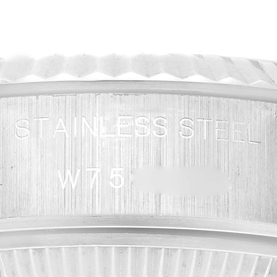 This is a close-up of the side of the case of a Rolex Datejust 69174 Women's Stainless Steel Silver Dial 69174 Women's Stainless Steel Silver Dial watch, showing "STAINLESS STEEL" and part of the serial number.
