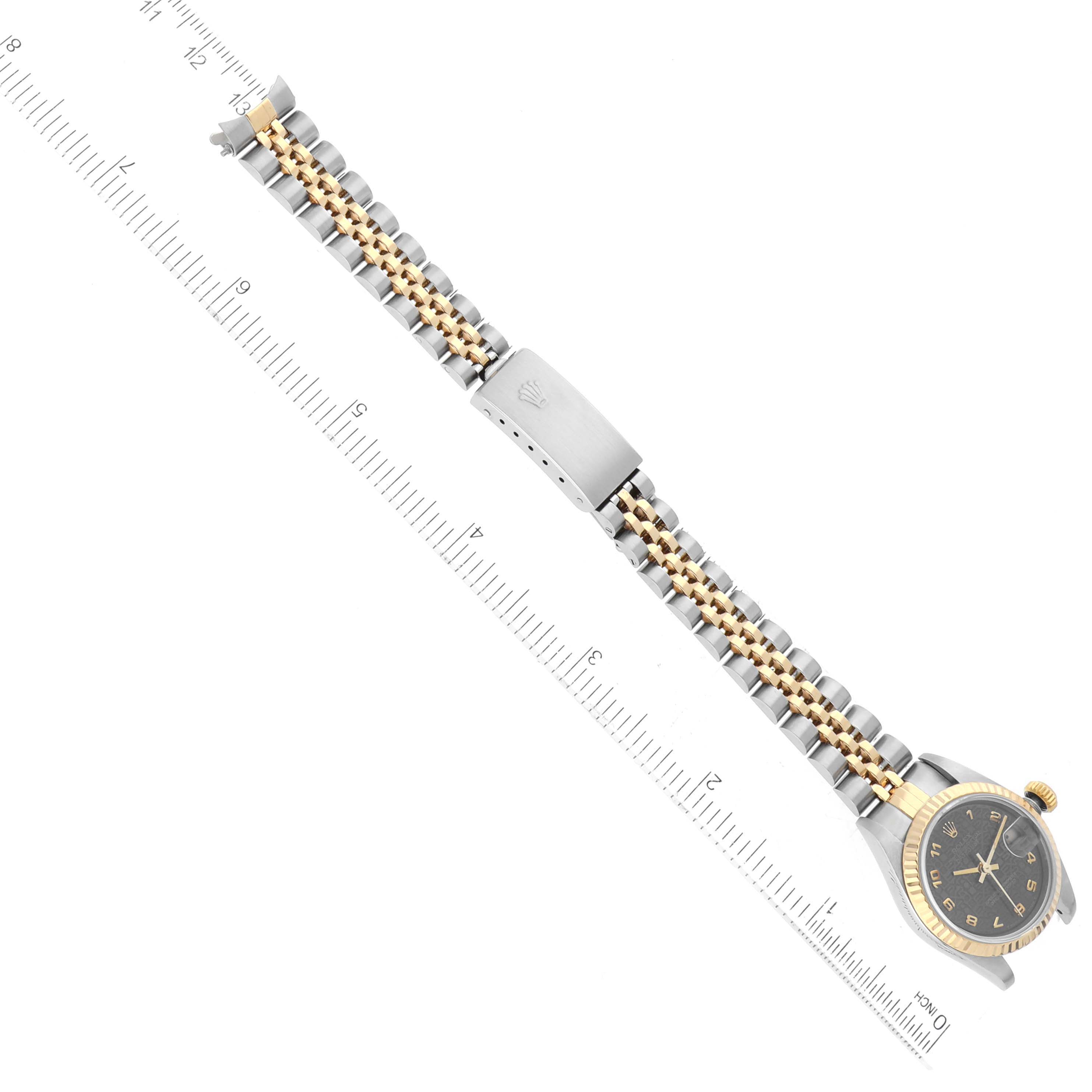 The image shows a Rolex Datejust 79173 Women's Steel and Gold (two tone) Black Dial 79173 Women's Steel and Gold (two tone) Black Dial watch from a top-down angle, highlighting the entire watch and its two-tone bracelet next to a ruler.