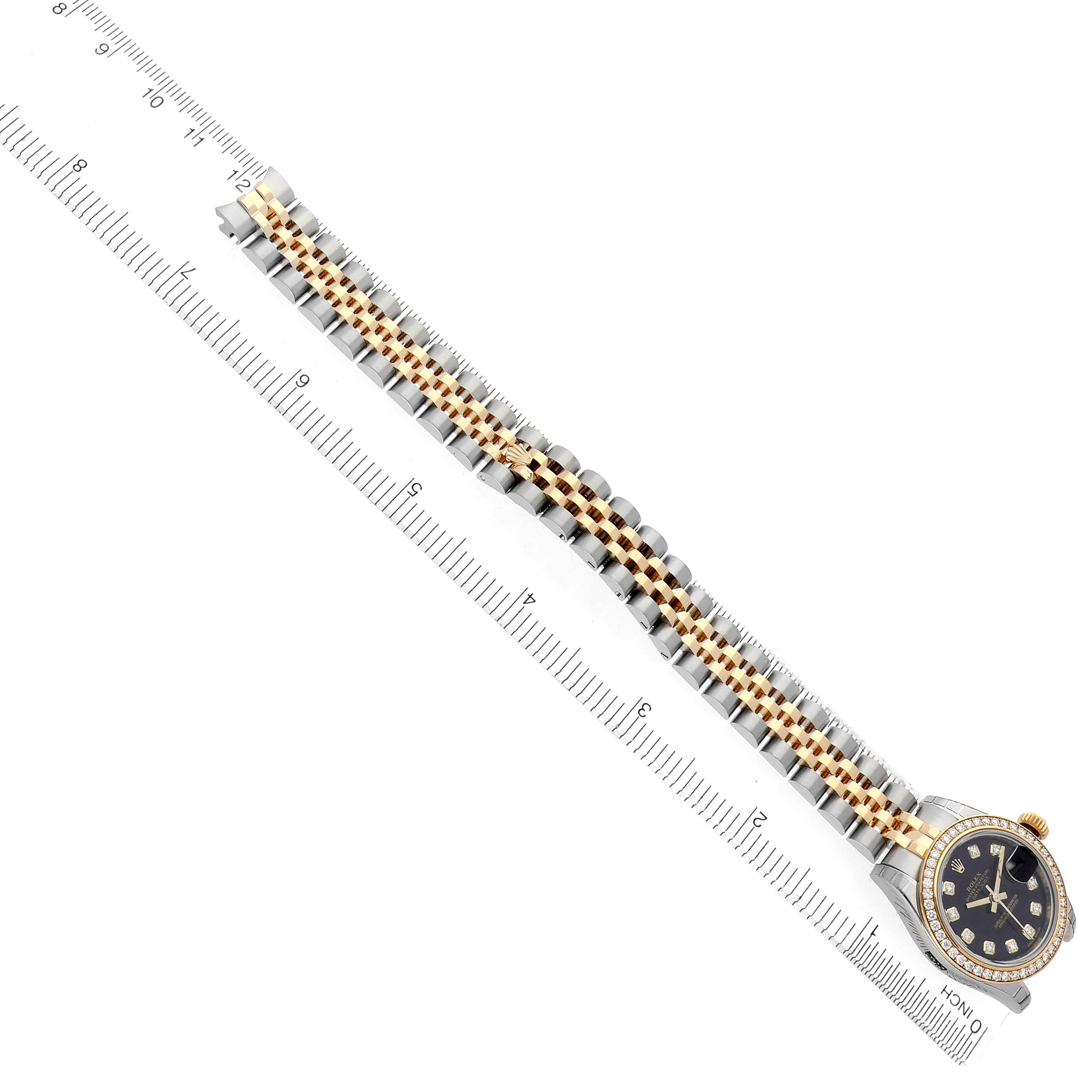 The image shows a Rolex Datejust 179383 Women
s Steel and Gold (two tone) Black Dial 179383 Women
s Steel and Gold (two tone) Black Dial watch at an angle, highlighting the bracelet and face alongside a measuring ruler.