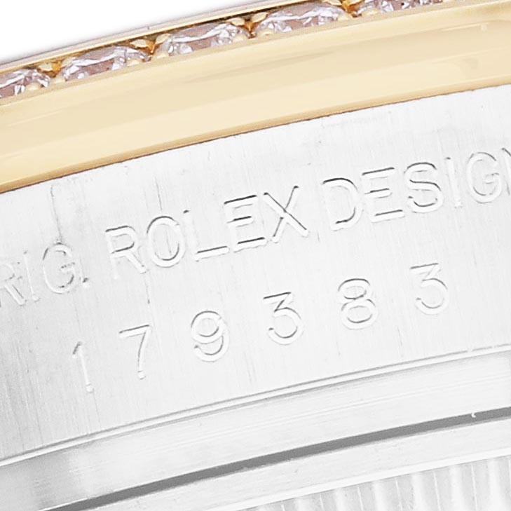 The image shows a close-up of the bezel and edge of the case of a Rolex Datejust 179383 Women
s Steel and Gold (two tone) Black Dial 179383 Women
s Steel and Gold (two tone) Black Dial, highlighting engraved text and part of a diamond bezel.