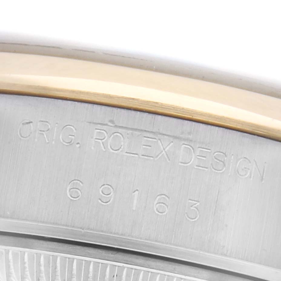 The image shows a close-up of the engraved side of the case of a Rolex Datejust 69163 Women
s Steel and Gold (two tone) Grey Dial 69163 Women
s Steel and Gold (two tone) Grey Dial watch, displaying its serial number.