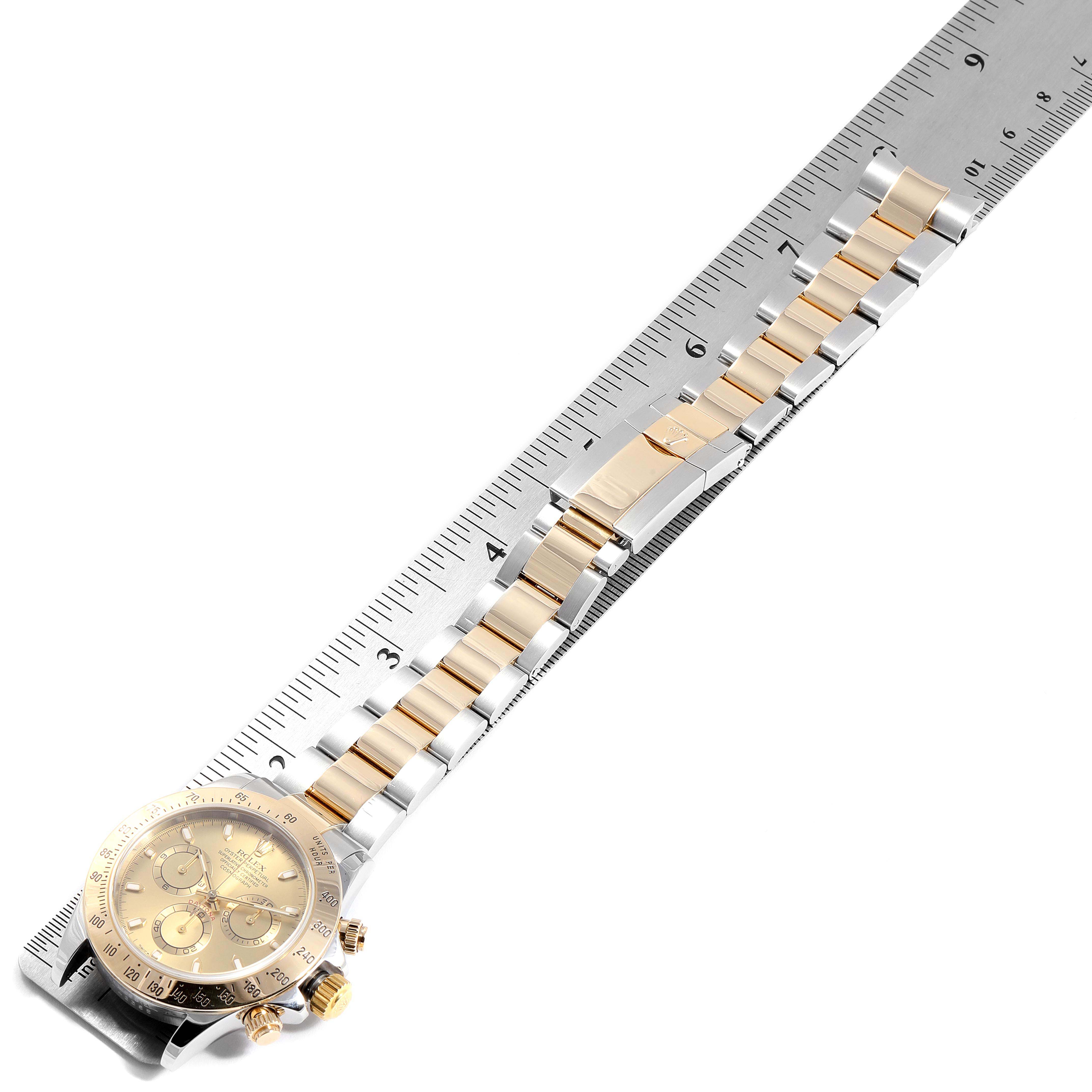 The Rolex Daytona 116523 Men
s Steel and Gold (two tone) Champagne Dial 116523 Men
s Steel and Gold (two tone) Champagne Dial watch is shown flat, face-up, alongside a ruler measuring its two-tone bracelet and face diameter.