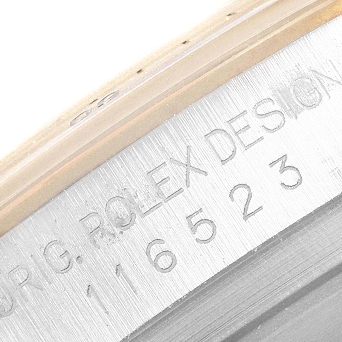 This image shows a close-up angle of the outer rim of the Rolex Daytona 116523 Men
s Steel and Gold (two tone) Champagne Dial 116523 Men
s Steel and Gold (two tone) Champagne Dial watch with the engraving text visible.