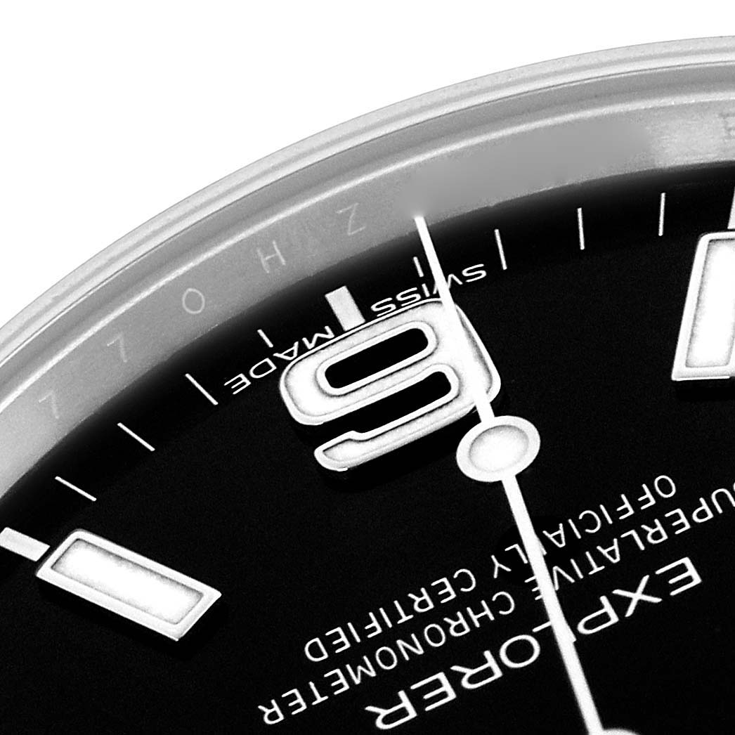 The image shows a close-up of the Rolex Explorer 214270 Men
s Stainless Steel Black Dial 214270 Men
s Stainless Steel Black Dial watch face, highlighting the "6" marker, part of the dial, and "Swiss Made" text.