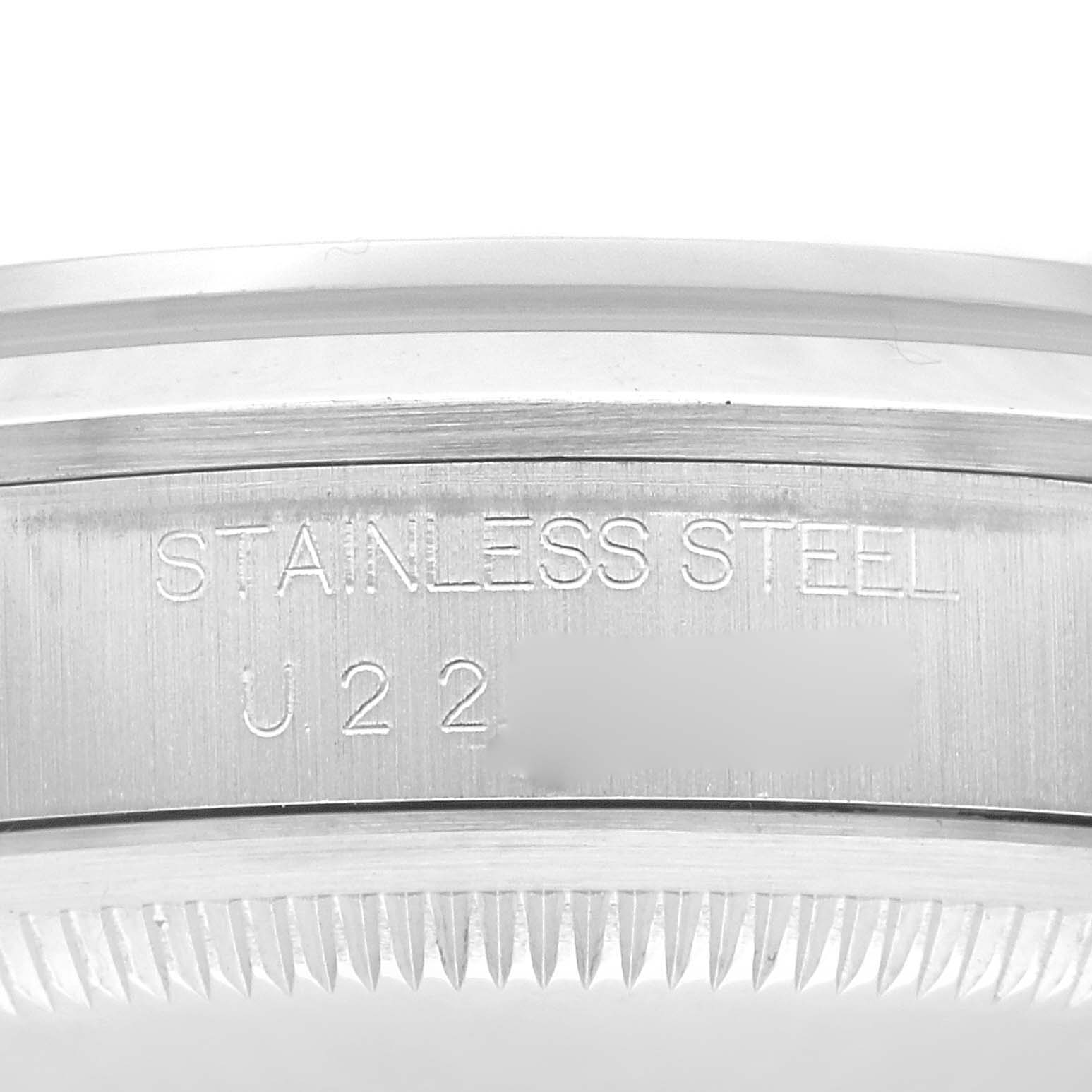 The image shows the side of a Rolex Explorer 14270 Men
s Stainless Steel Black Dial 14270 Men
s Stainless Steel Black Dial watch, highlighting its stainless steel case with an engraved serial number.