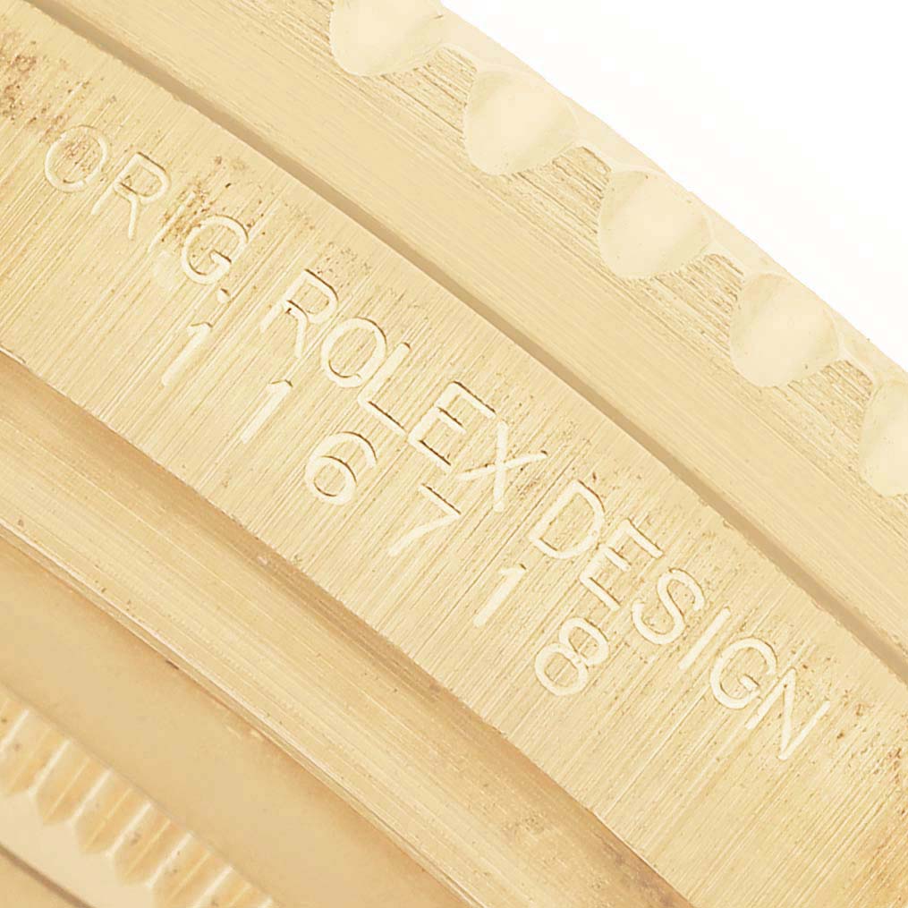 The image shows a close-up of the engraved inner bezel of a Rolex GMT-Master 116718 Mens Yellow Gold Green Dial watch, displaying model and design details.
