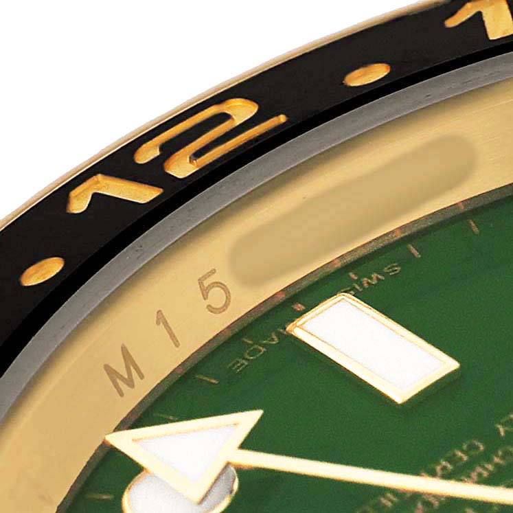The image shows a close-up of the bezel and dial of a Rolex GMT-Master 116718 Men's Yellow Gold Green Dial watch, highlighting the numbers and hour marker.