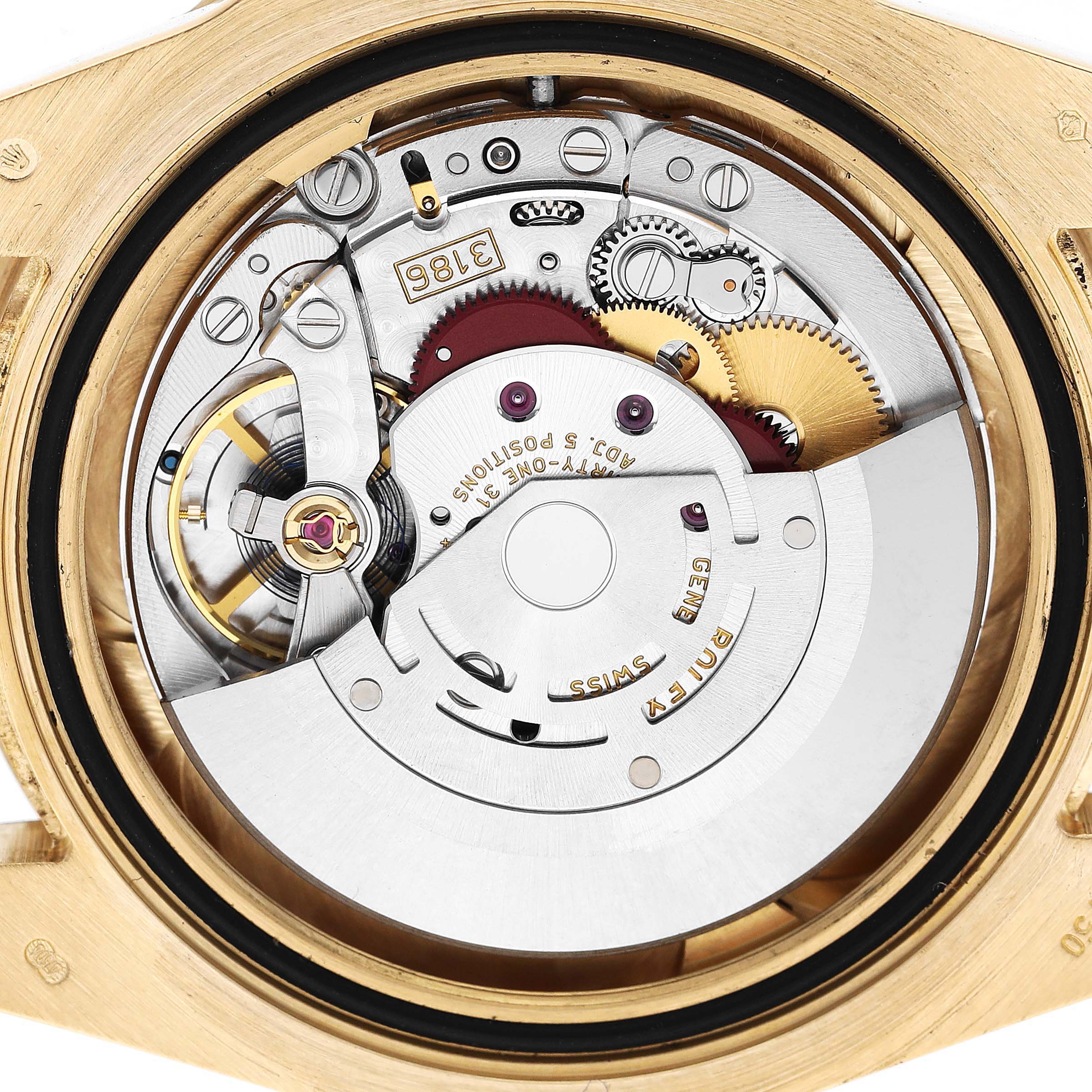 The image shows the movement and mechanics of a Rolex GMT-Master 116718 Men's Yellow Gold Green Dial watch from a rear angle, displaying gears and the rotor.