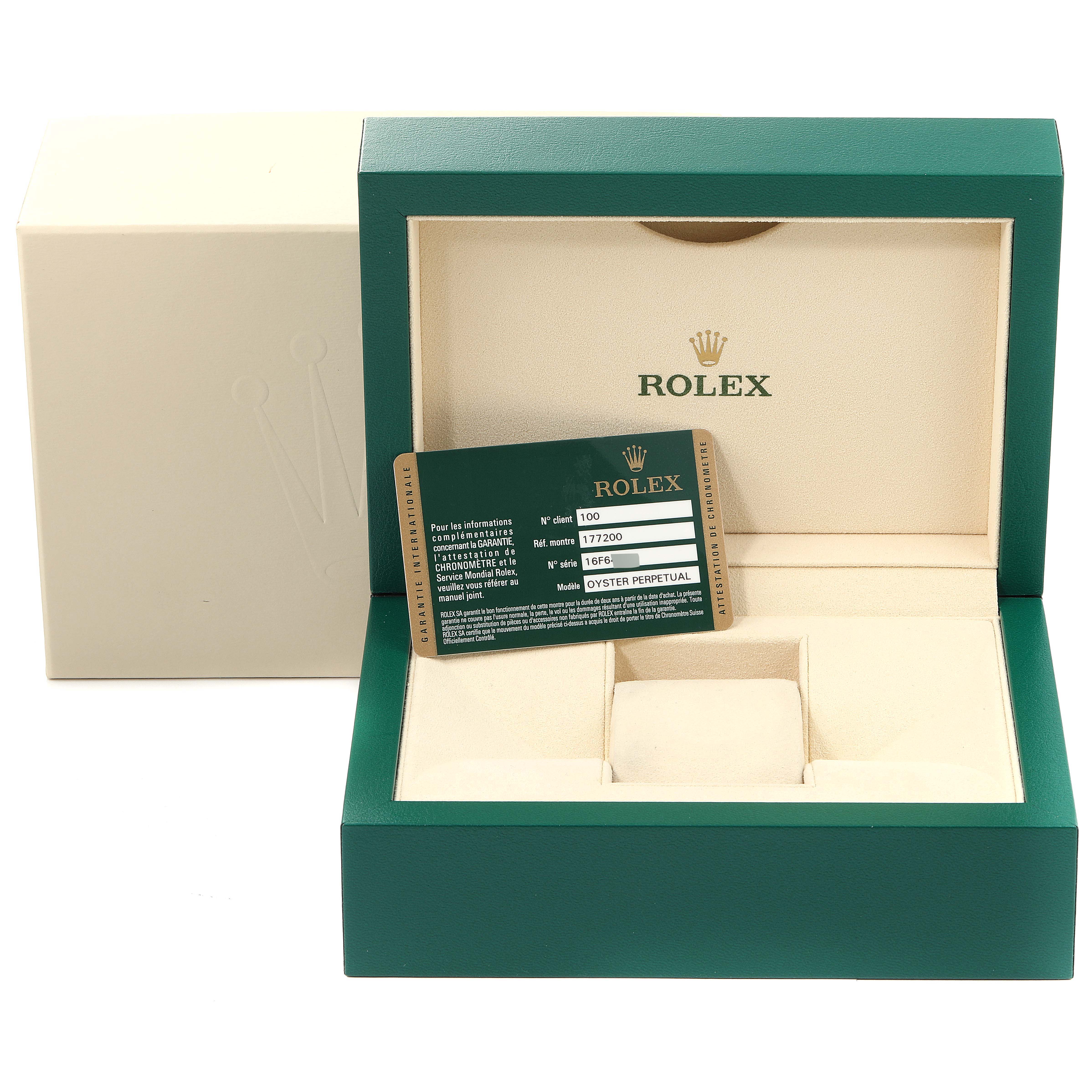This image shows the open box of a Mid-Size Rolex, featuring the trademark green and gold color scheme and a warranty card.
