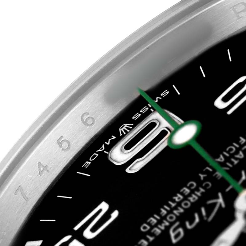The image shows a close-up of the Rolex Air-King 126900 Men's Stainless Steel Black Dial watch face, highlighting the bezel, engraved numerals, and dial details.