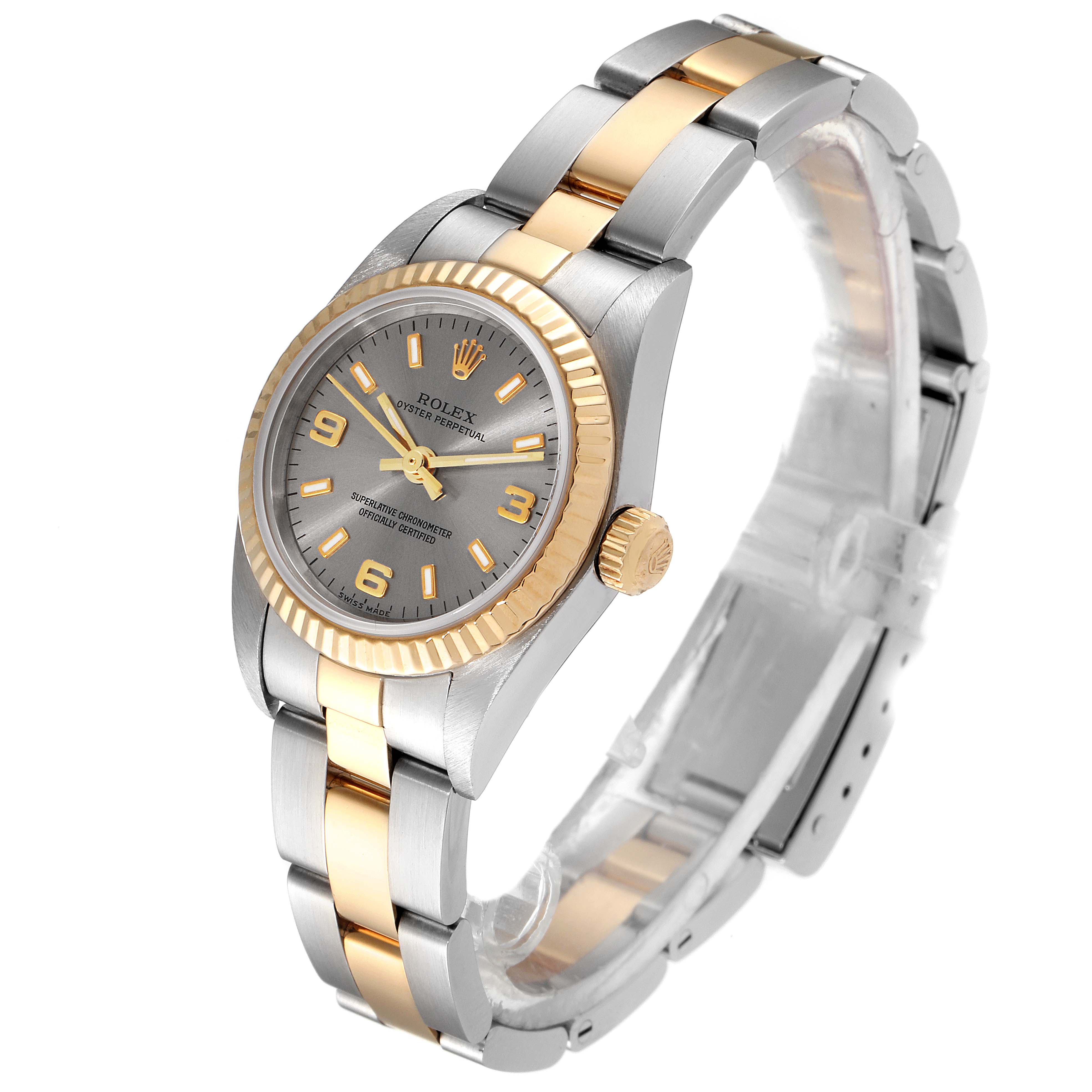 The image shows a side angle of a Rolex Oyster Perpetual 76193 Women's Steel and Gold (two tone) Grey Dial 76193 Women's Steel and Gold (two tone) Grey Dial watch, highlighting the gold bezel, crown, and two-tone bracelet.