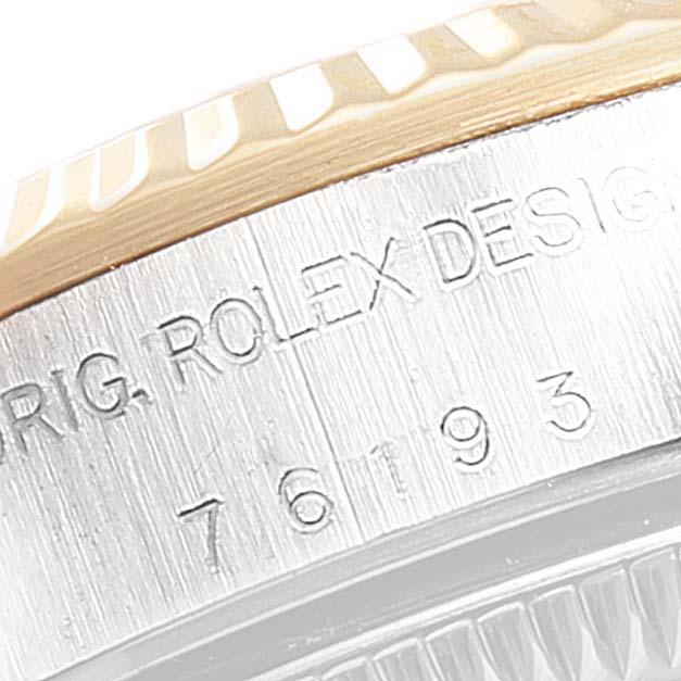 The image shows a close-up of the side of the Rolex Oyster Perpetual 76193 Women's Steel and Gold (two tone) Grey Dial 76193 Women's Steel and Gold (two tone) Grey Dial watch, focusing on the engraved model and design details.