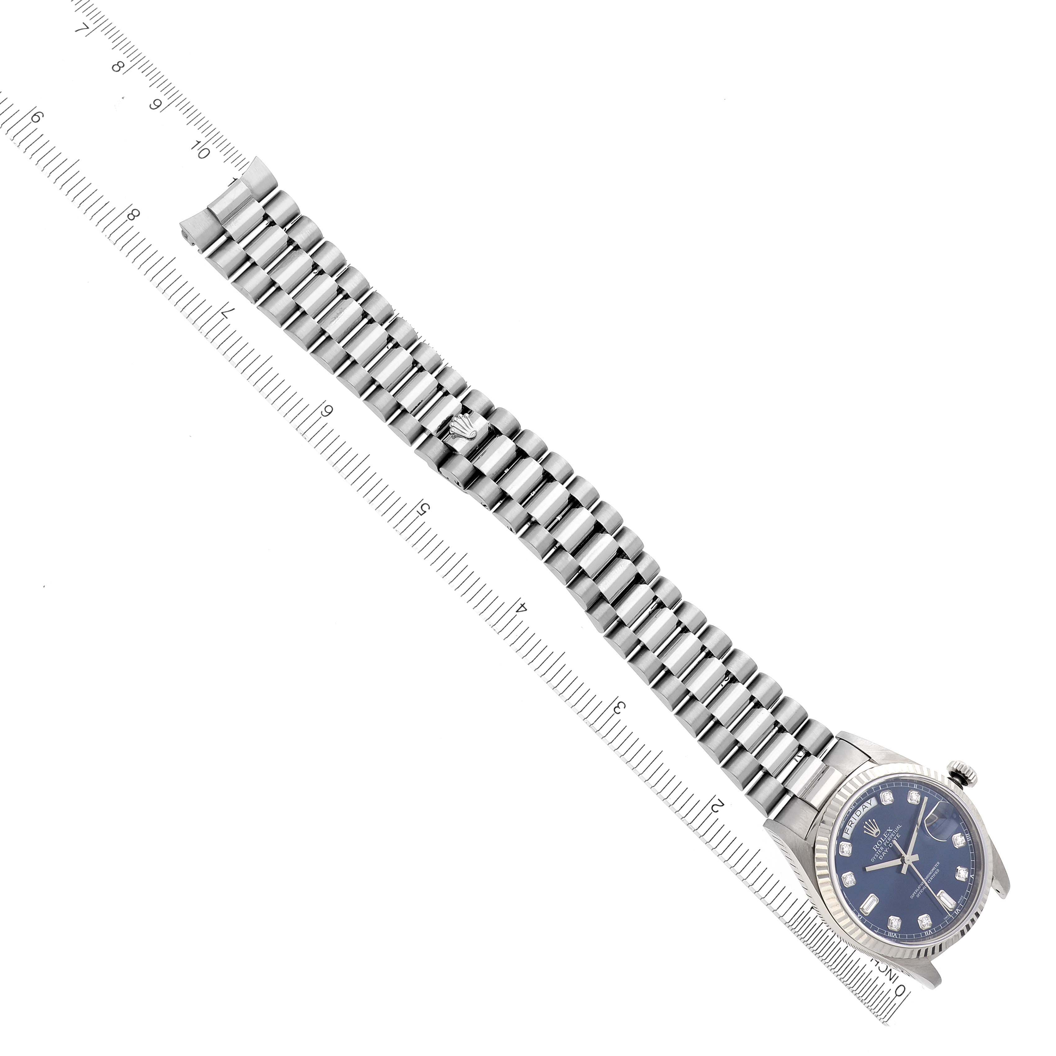 The image shows a Rolex President 18239A Men
s White Gold Blue Dial 18239A Men
s White Gold Blue Dial model watch from a top-down angle, highlighting the bracelet and face alongside a ruler for scale.