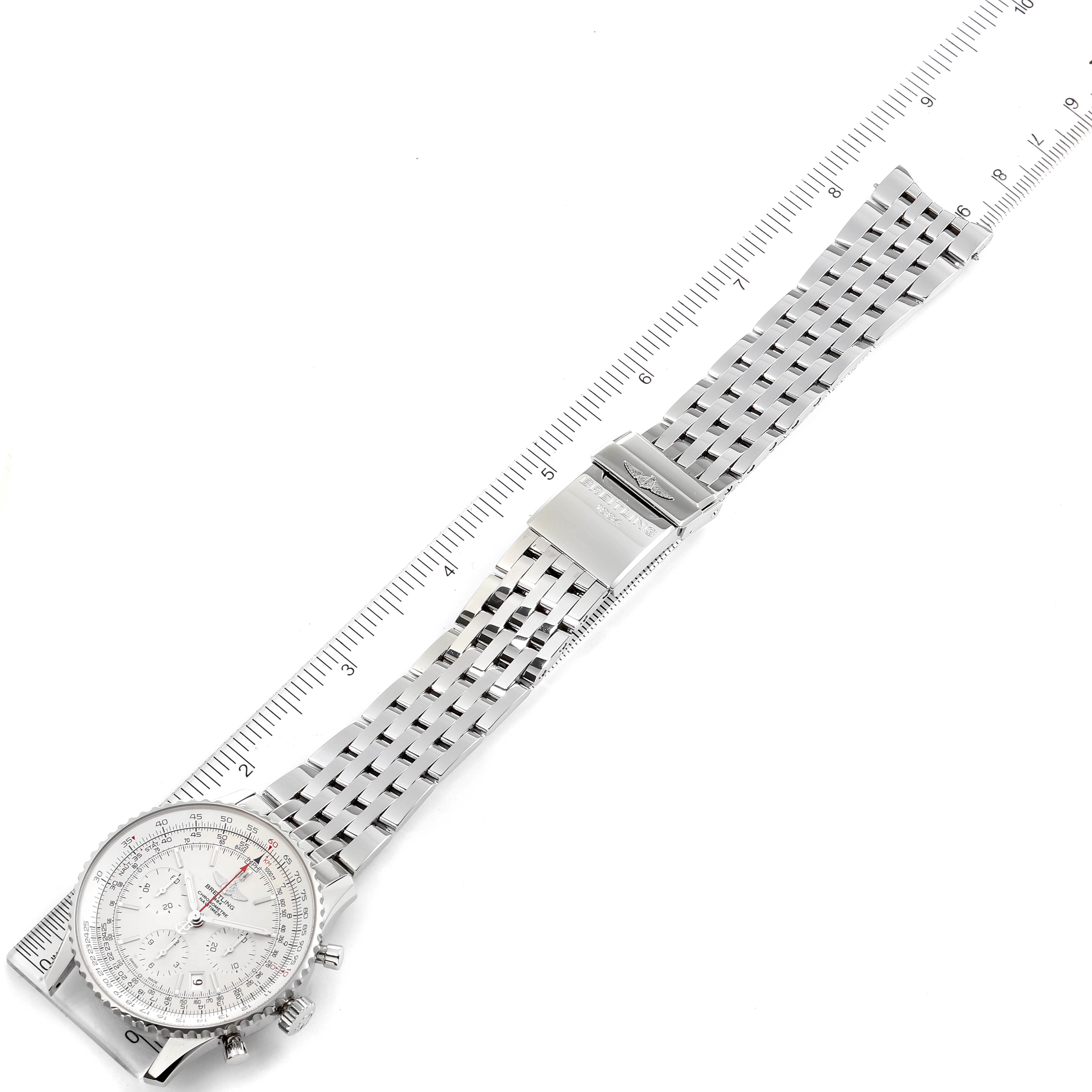 The image shows a top-down view of a Breitling Navitimer AB0123 Men's Stainless Steel Silver Dial AB0123 Men's Stainless Steel Silver Dial watch with its full metal bracelet extended next to a ruler.