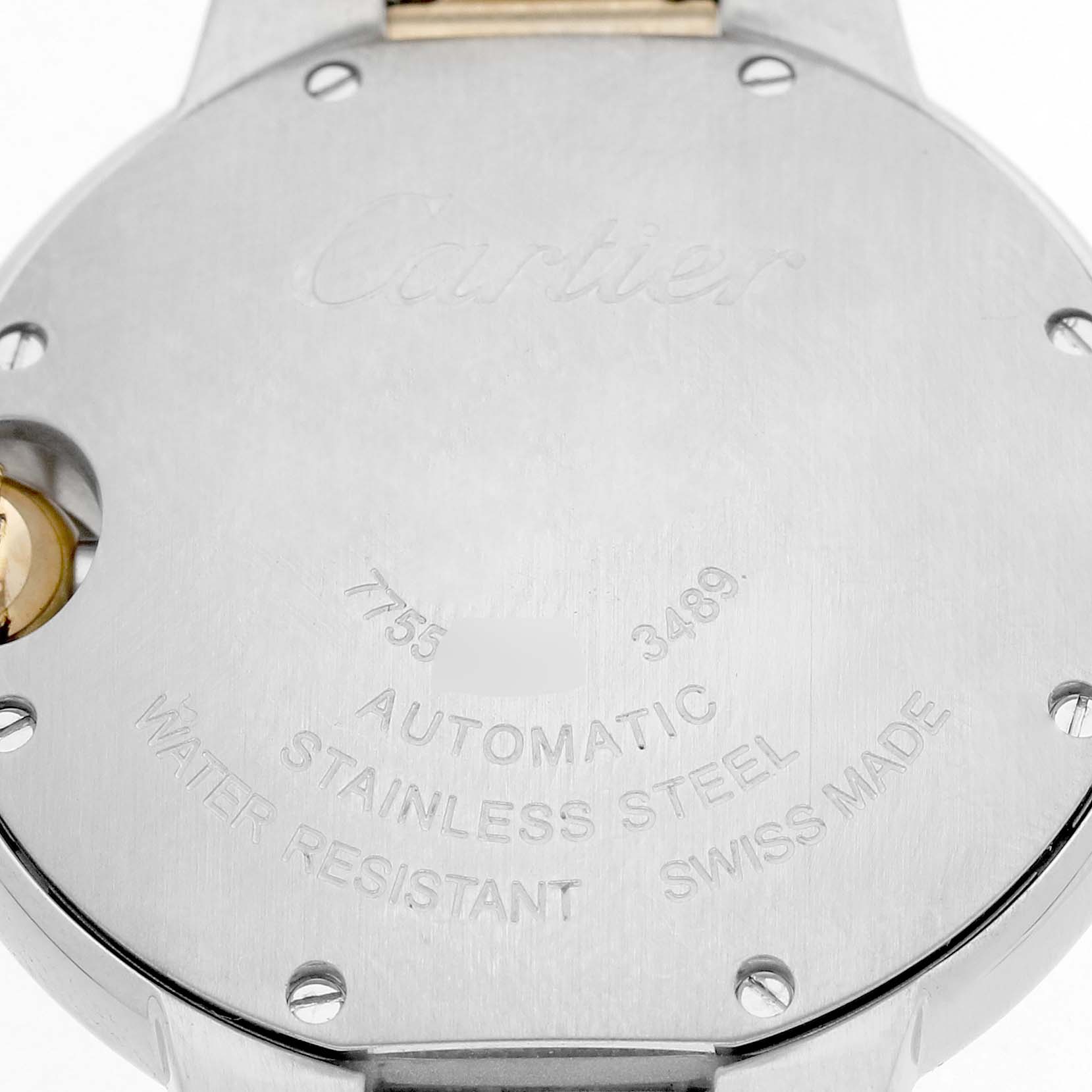 The image shows the stainless steel case back of a Cartier Ballon Bleu W2BB0002 Women's Stainless Steel Silver Dial watch, displaying engravings and screws.
