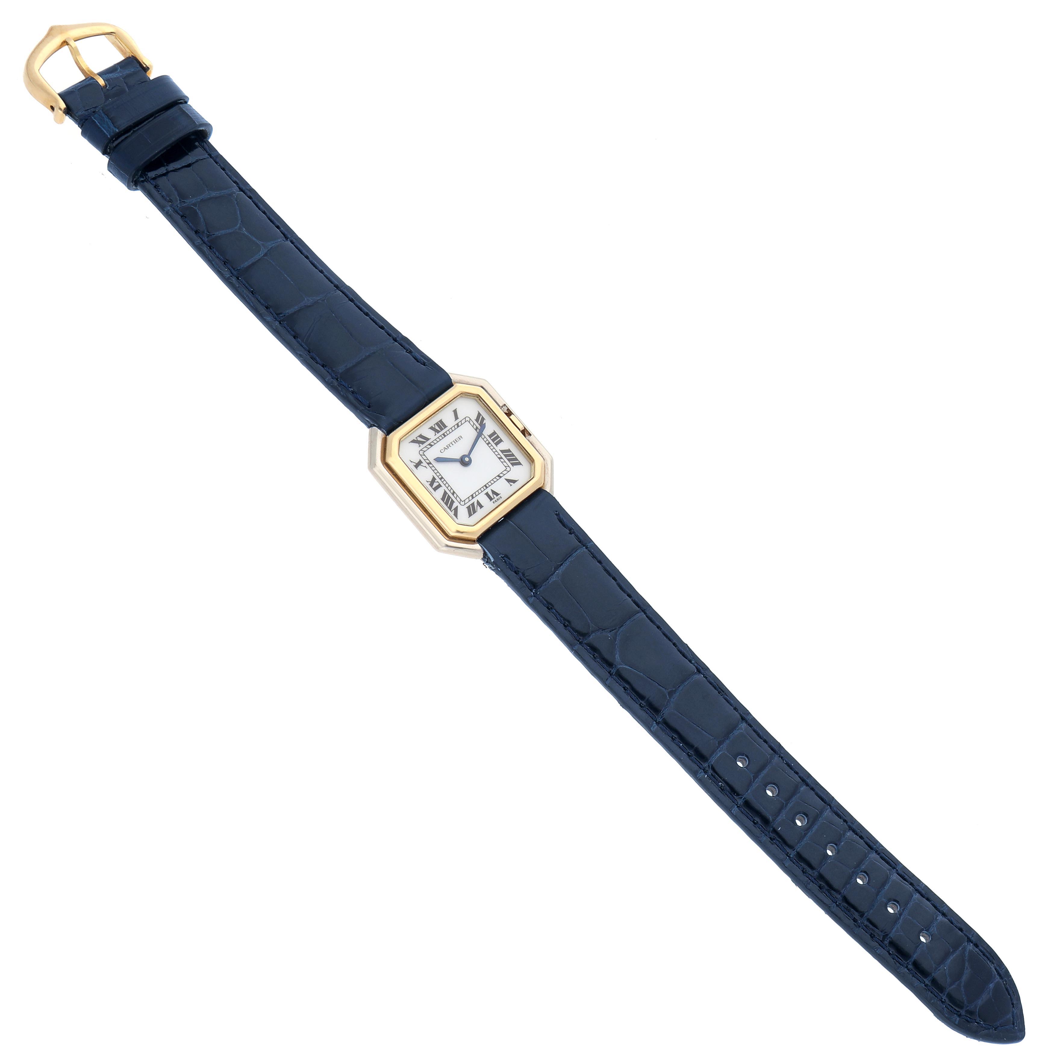 The Cartier Ceinture 78100 Women
s Steel and Gold (two tone) White Dial 78100 Women
s Steel and Gold (two tone) White Dial watch is shown from a top view, featuring its octagonal face, blue strap, and gold buckle.