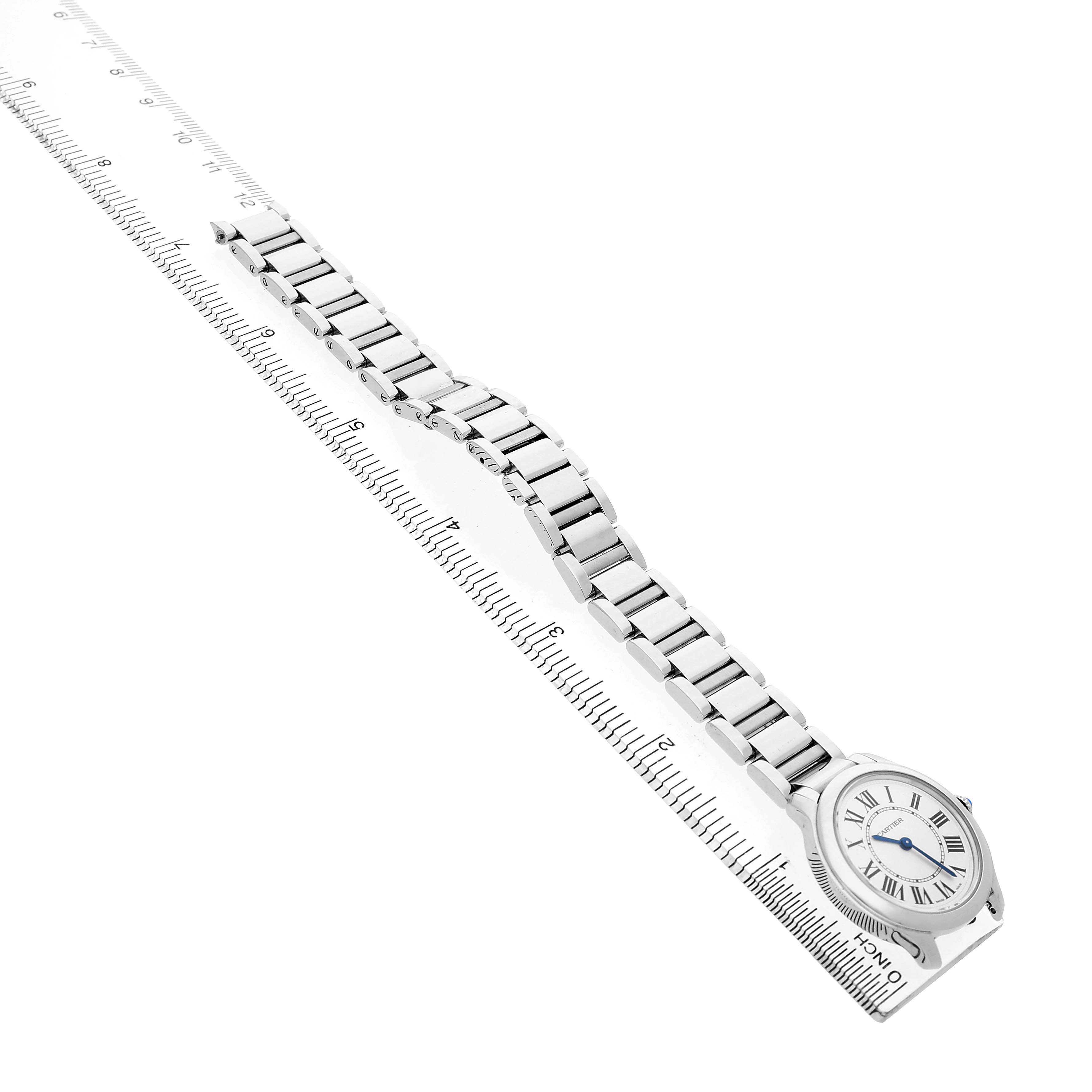 The Cartier Ronde WSRN0033 Women's Stainless Steel Silver Dial watch is shown from a top-down angle, displaying the face and entire metal bracelet next to a ruler.