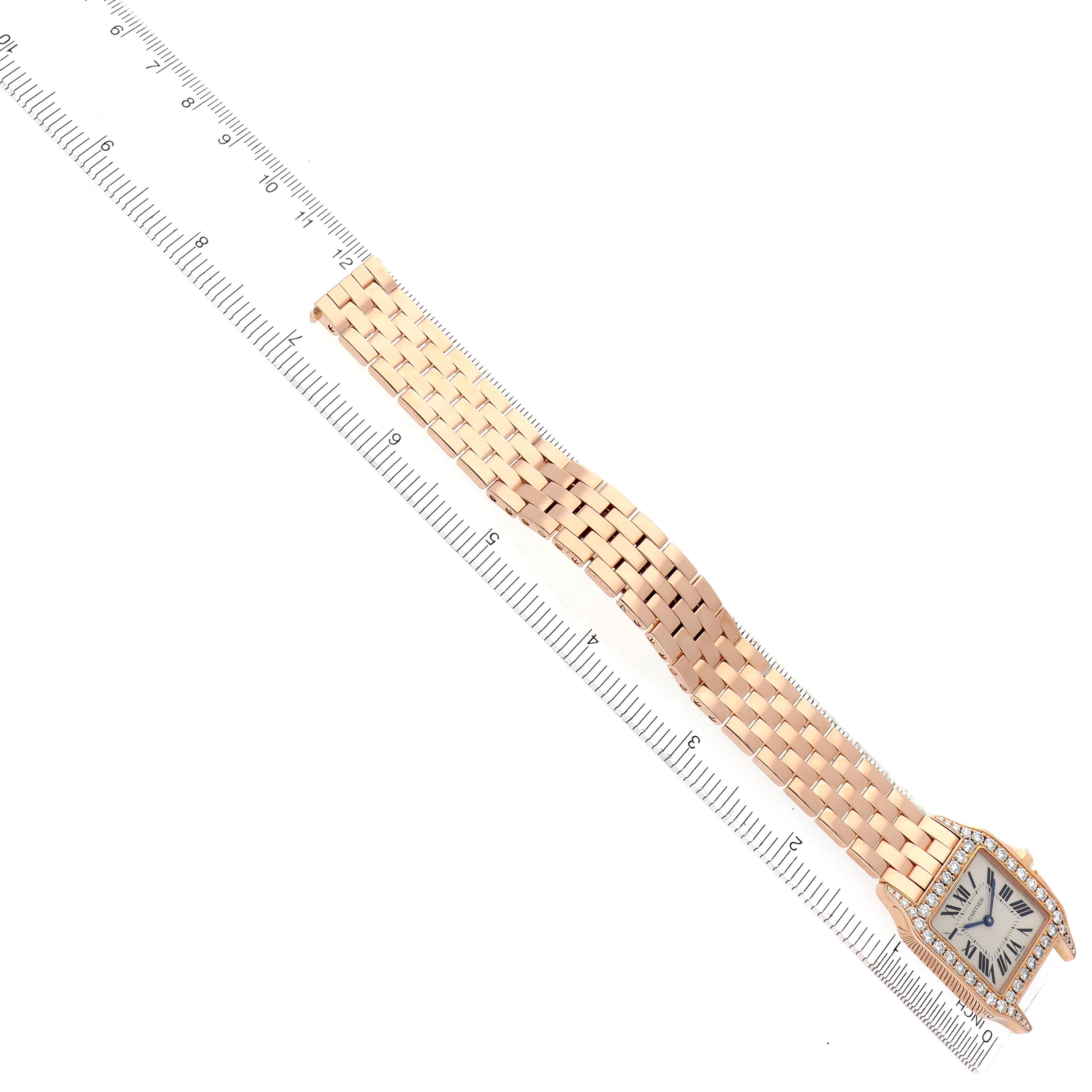The Cartier Santos Demoiselle WF9007Z8 Women
s Rose Gold Silver Dial WF9007Z8 Women
s Rose Gold Silver Dial watch is shown flat, highlighting its face and entire bracelet against a ruler for scale.