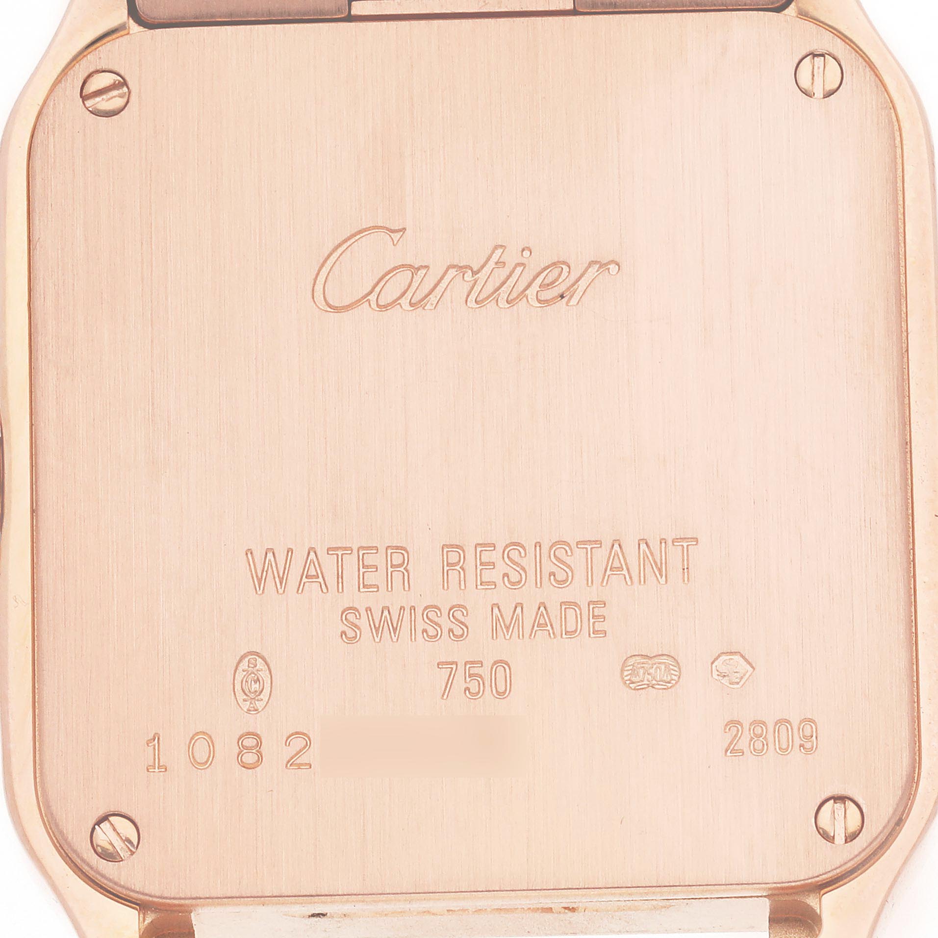 The image shows the back casing of a Cartier Santos Demoiselle WF9007Z8 Women
s Rose Gold Silver Dial WF9007Z8 Women
s Rose Gold Silver Dial watch, featuring engravings and screws.