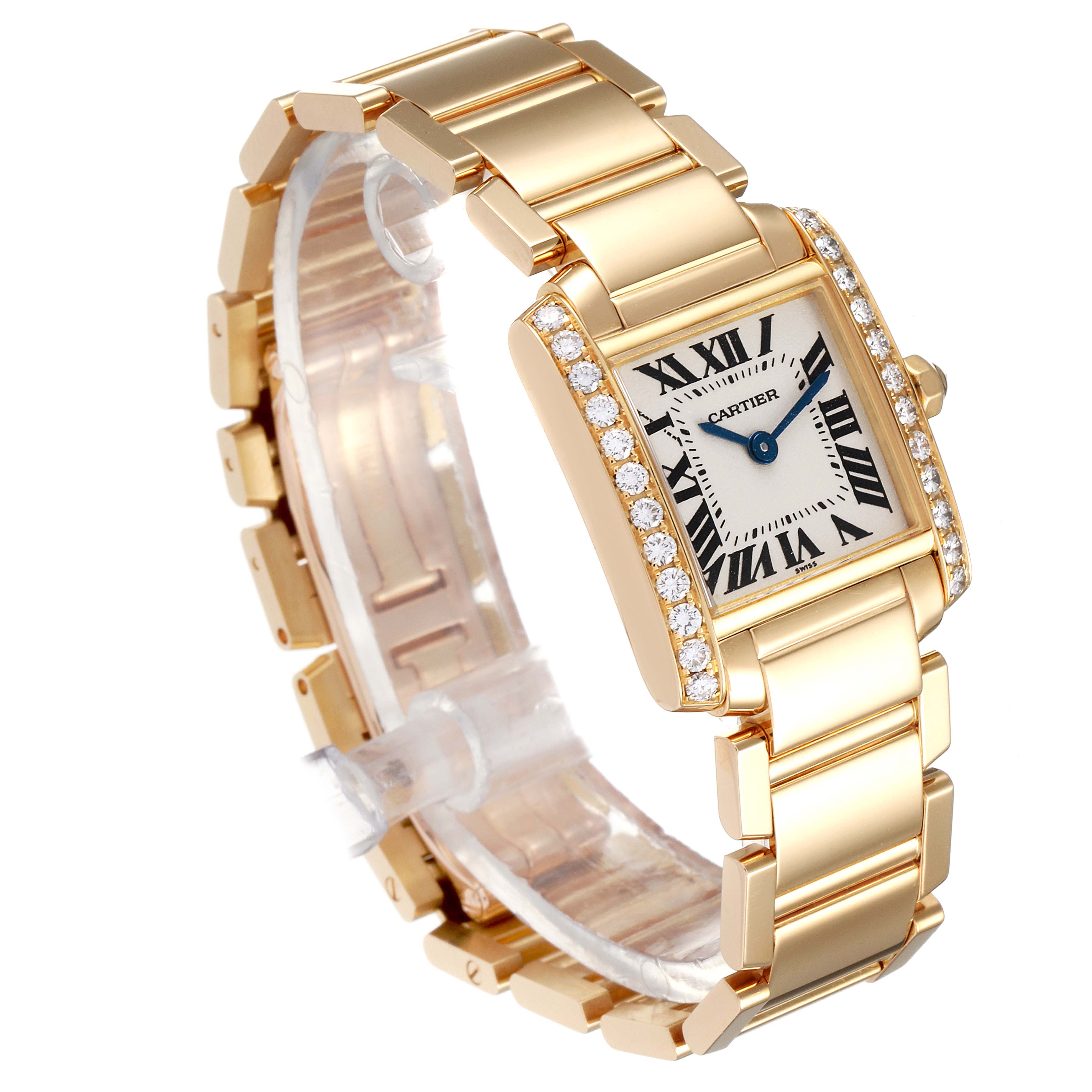 The Cartier Tank Francaise WE1001R8 Women
s Yellow Gold Silver Dial WE1001R8 Women
s Yellow Gold Silver Dial watch is shown from a front-side angle, highlighting its gold bracelet and diamond-encrusted rectangular face.