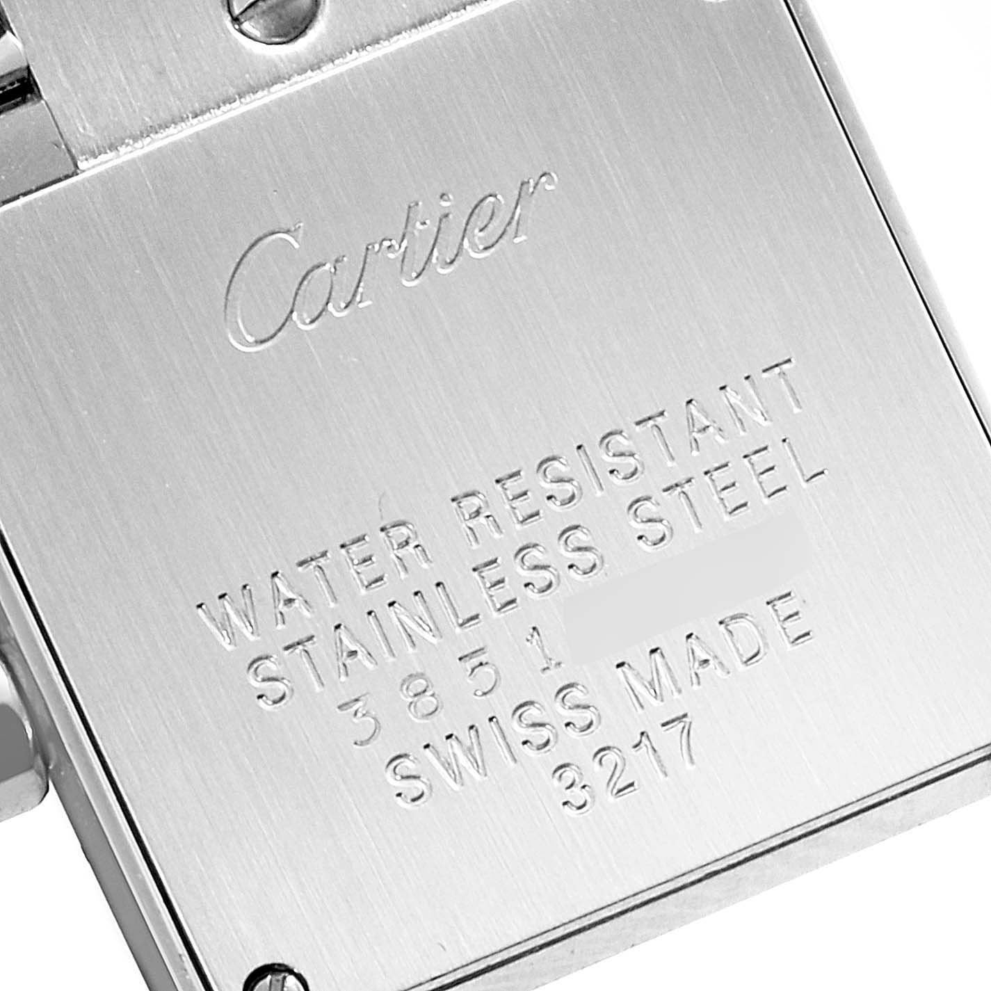 The image shows the back casing of a Cartier Tank Française watch, featuring engraved details about water resistance and material.