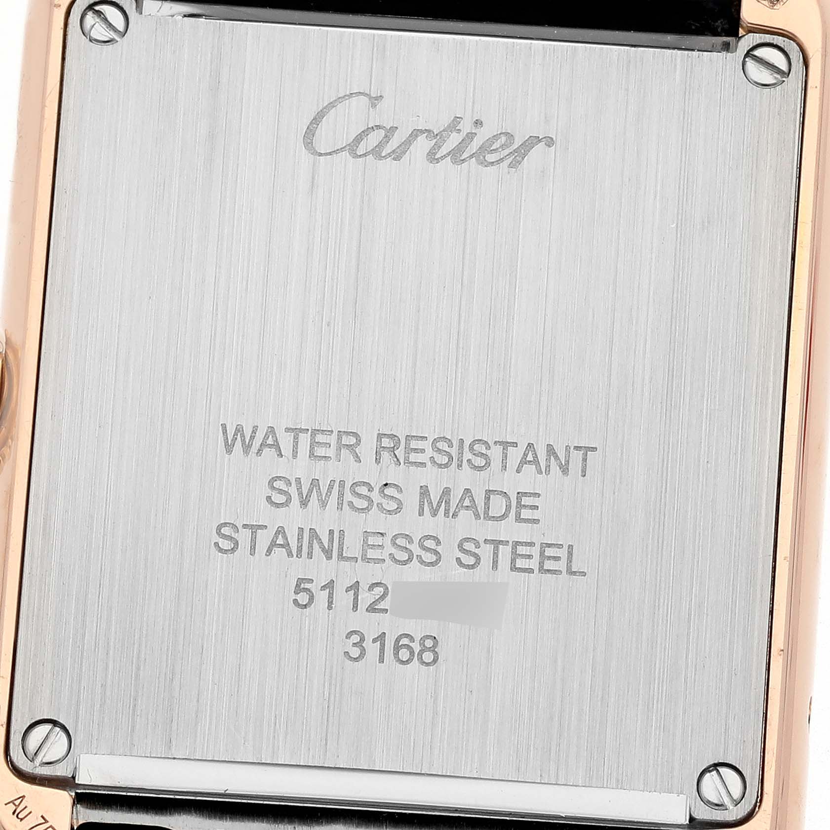 The image shows the back case of a Cartier Tank Solo W5200024 Women's Steel and Gold (two tone) Silver Dial W5200024 Women's Steel and Gold (two tone) Silver Dial watch, displaying its inscriptions and screws.