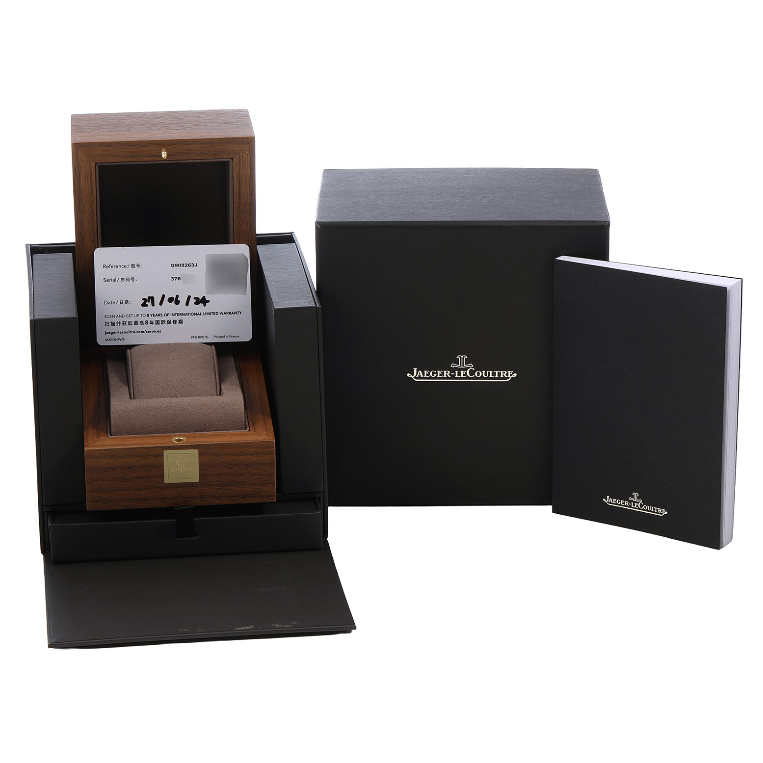 The image shows the packaging and accessories for a Jaeger-LeCoultre Polaris watch, including a wooden box, warranty card, outer box, and booklet.
