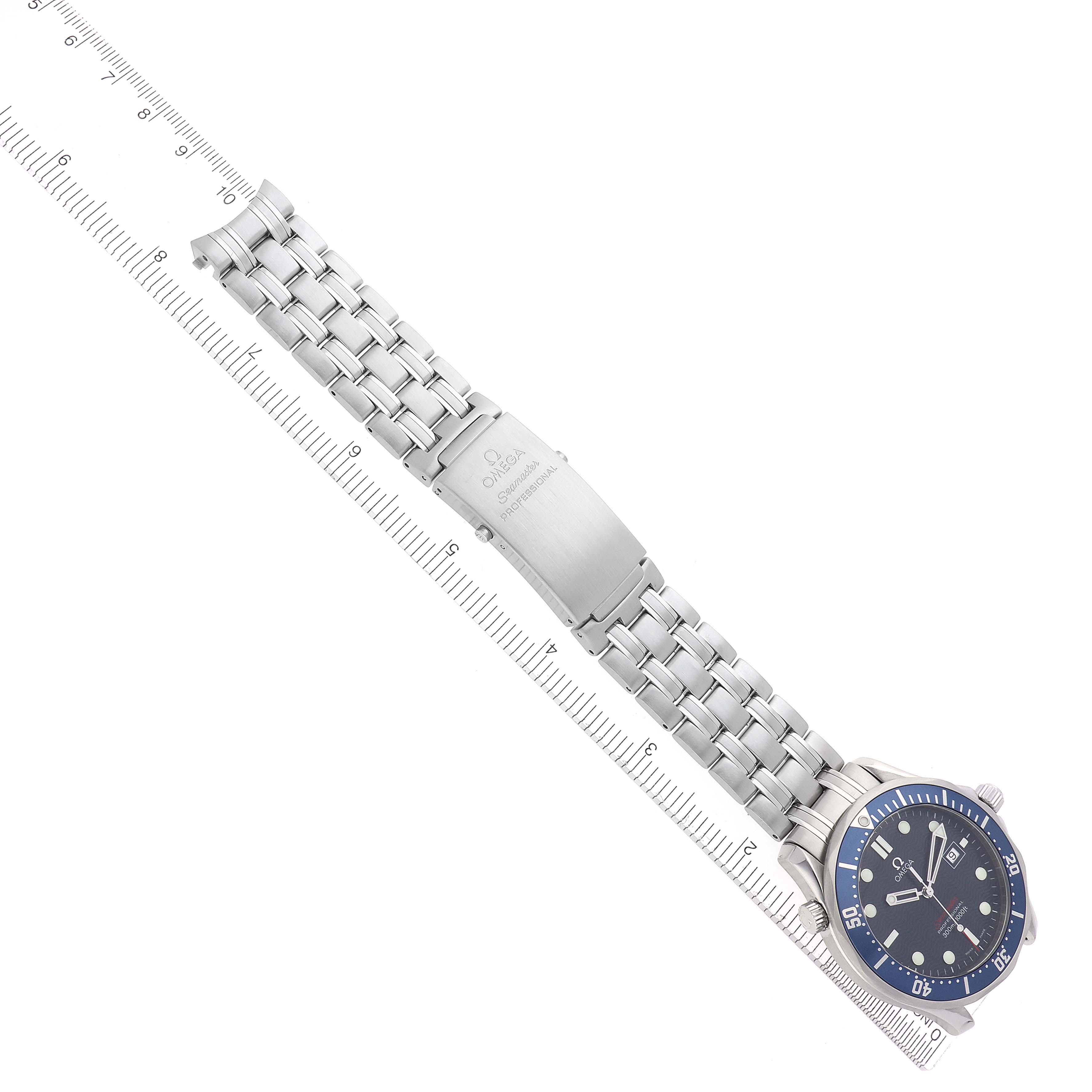 The image shows an Omega Seamaster 2221.80.00 Men
s Stainless Steel Blue Dial 2221.80.00 Men
s Stainless Steel Blue Dial watch at an angled top view, displaying the full bracelet, clasp, and bezel against a ruler.