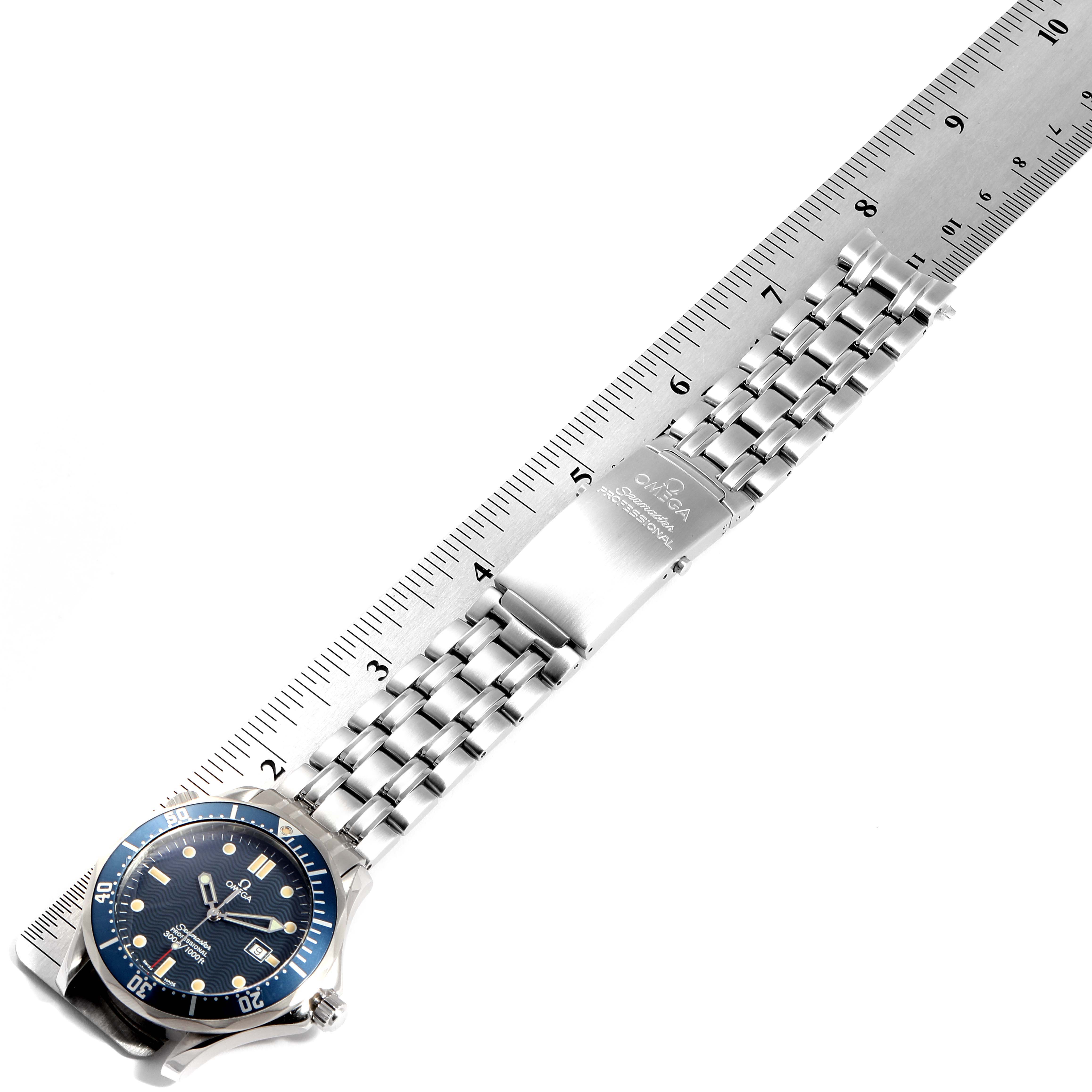 The image shows an Omega Seamaster 2541.80.00 Men
s Stainless Steel Blue Dial 2541.80.00 Men
s Stainless Steel Blue Dial watch lying flat with its face, bracelet, and clasp visible, next to a ruler for scale.