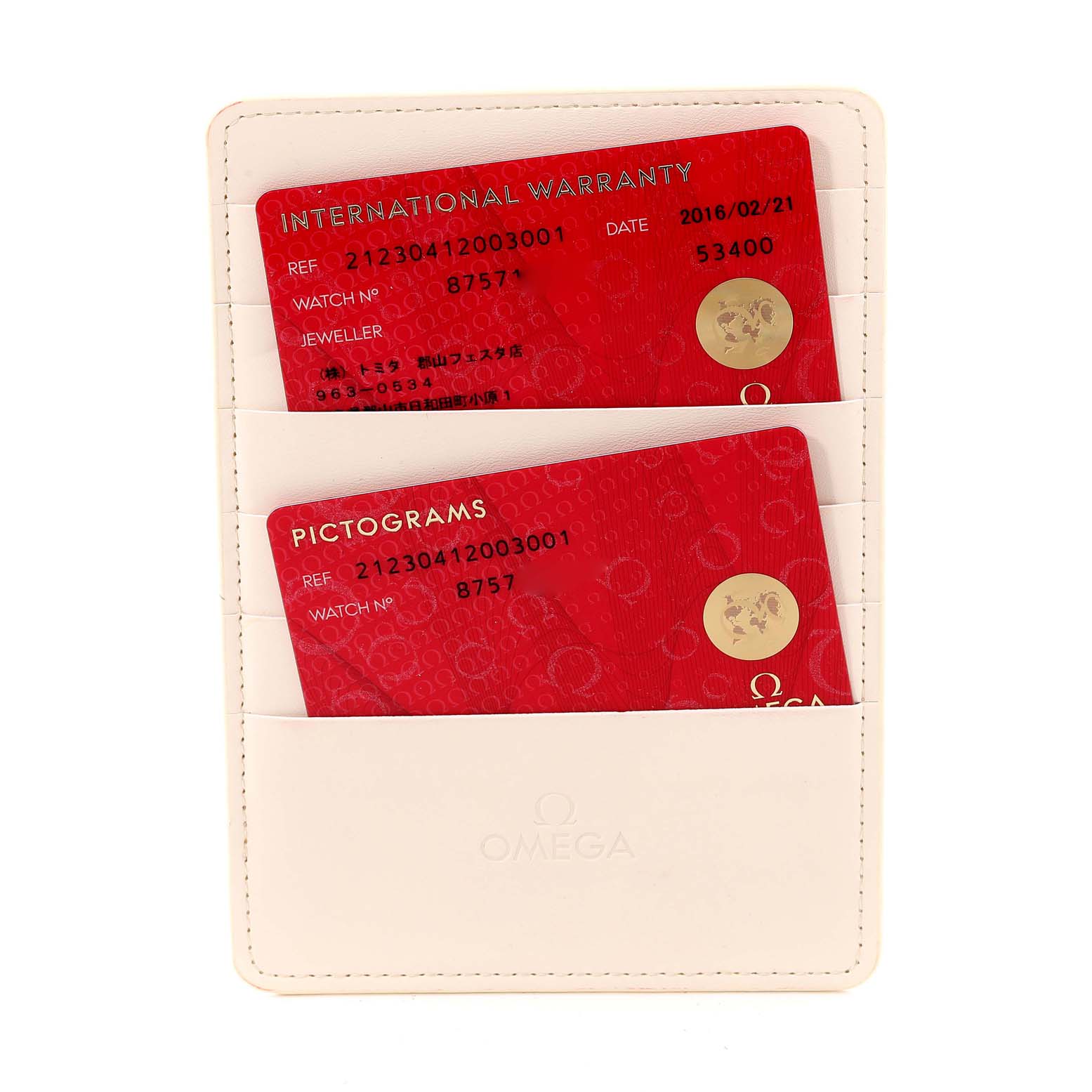 The image shows a white Omega cardholder containing the International Warranty and Pictograms cards for a Seamaster model.