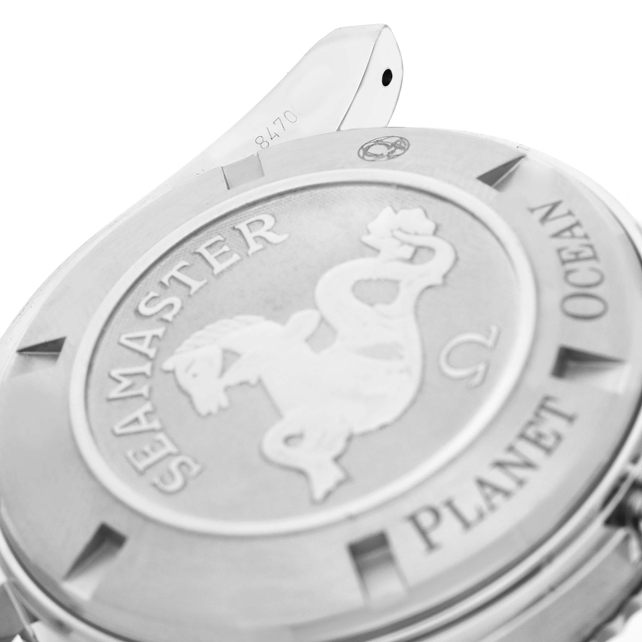 The image shows the case back of the Omega Seamaster Planet Ocean, featuring the Seamaster logo and branding details.