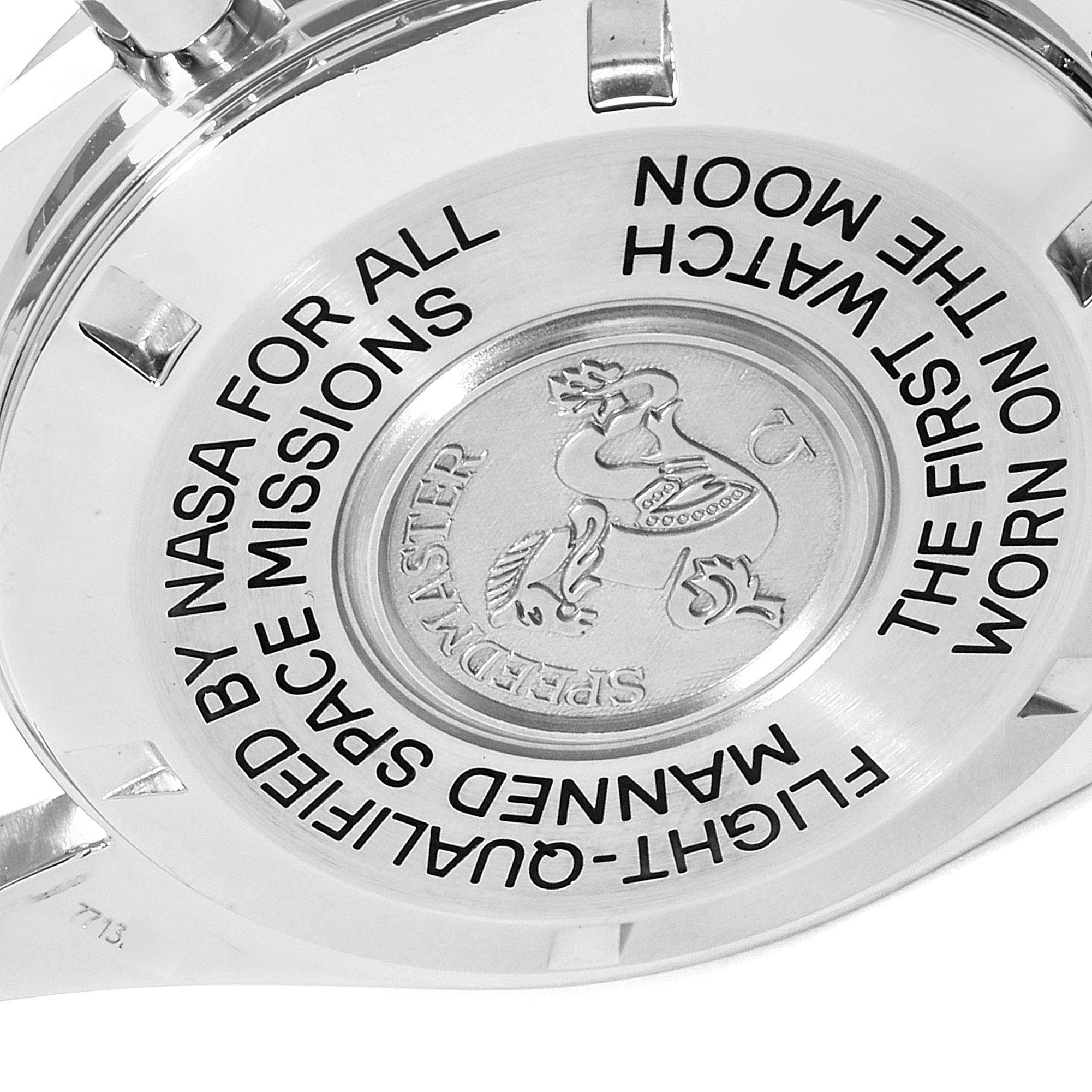 The image shows the backside of an Omega Speedmaster 3575.30.00 Men
s Stainless Steel Silver Dial 3575.30.00 Men
s Stainless Steel Silver Dial watch with engraved text and emblem.