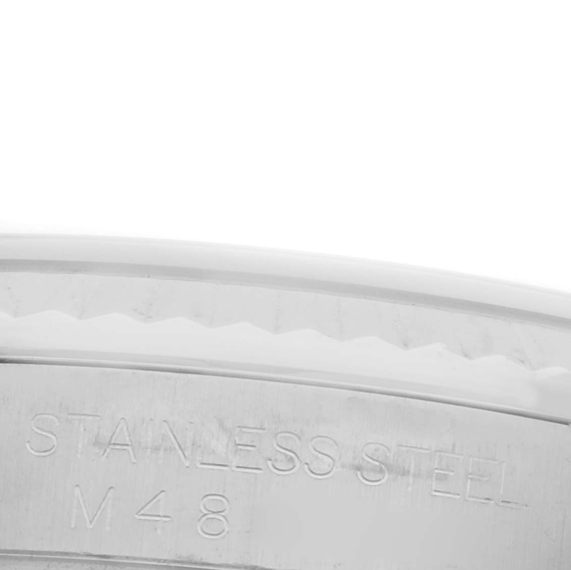 The image shows a close-up of the side of a stainless steel case back of a Rolex Datejust 116234 Men's Stainless Steel White Dial 116234 Men's Stainless Steel White Dial, featuring engraving details.