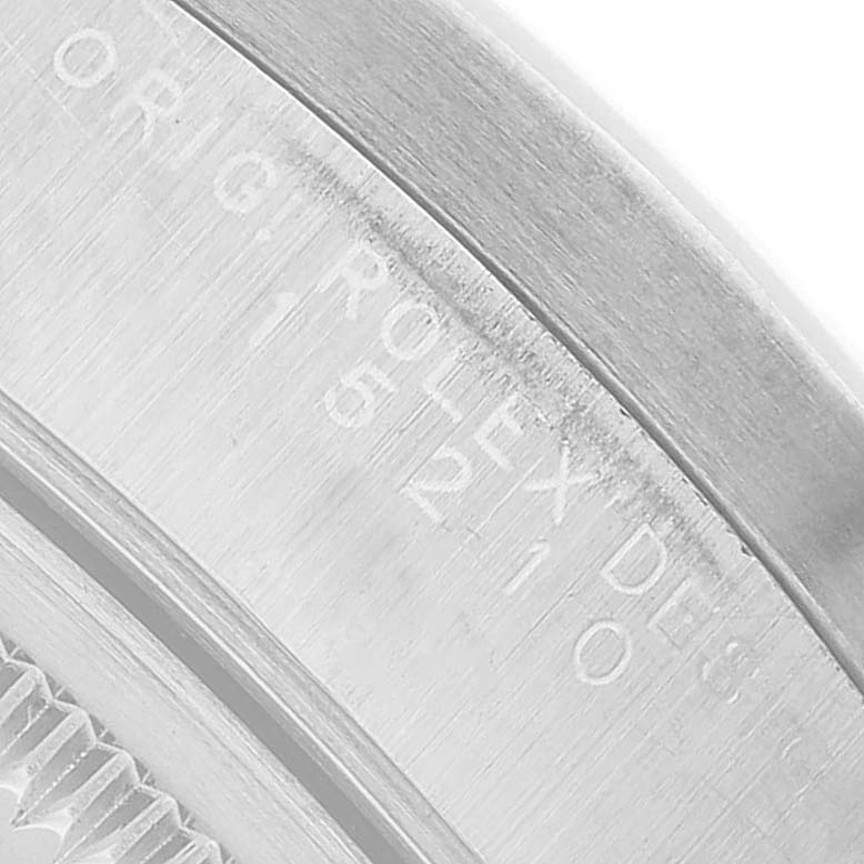 The image shows a close-up of the inner engraving and part of the bezel of a Rolex Date 15210 Men's Stainless Steel Silver Dial watch.