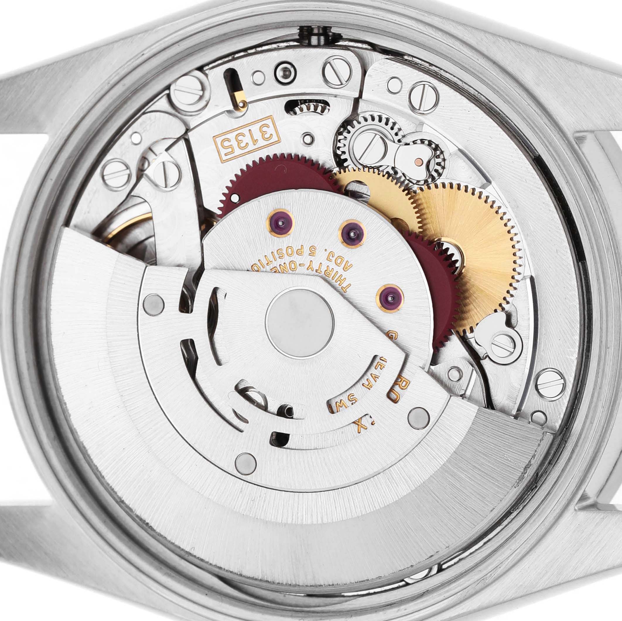 The image shows the exposed movement of a Rolex Date 15210 Men's Stainless Steel Silver Dial model watch, highlighting its gears and mechanical components.