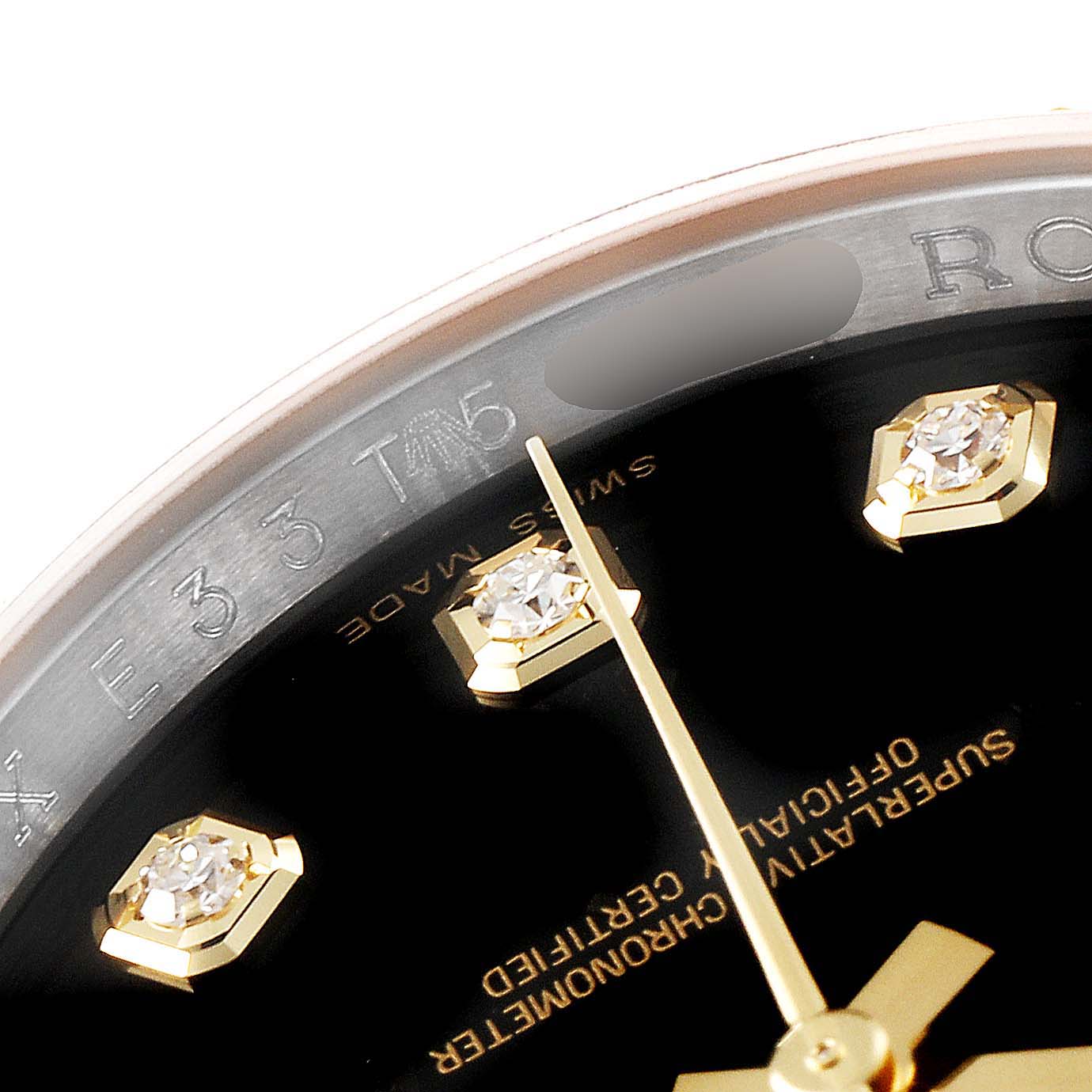 This close-up of a Rolex Datejust 116233 Men's Steel and Gold (two tone) Black Dial 116233 Men's Steel and Gold (two tone) Black Dial watch shows part of the dial, three hour markers, and the minute hand.